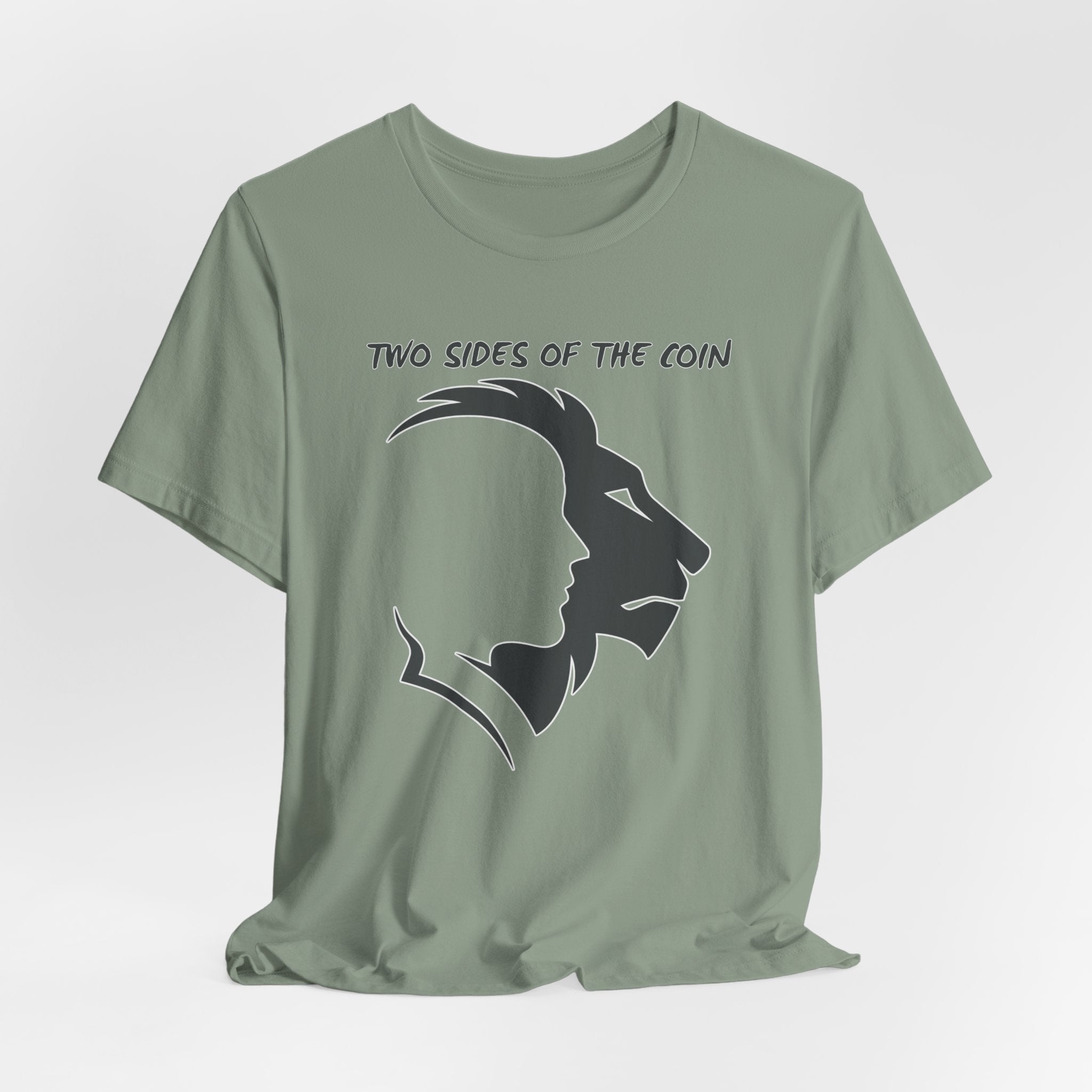 Sage green t-shirt with dark gray graphic of lion and human faces and text 'Two Sides of the Coin' on a light gray background