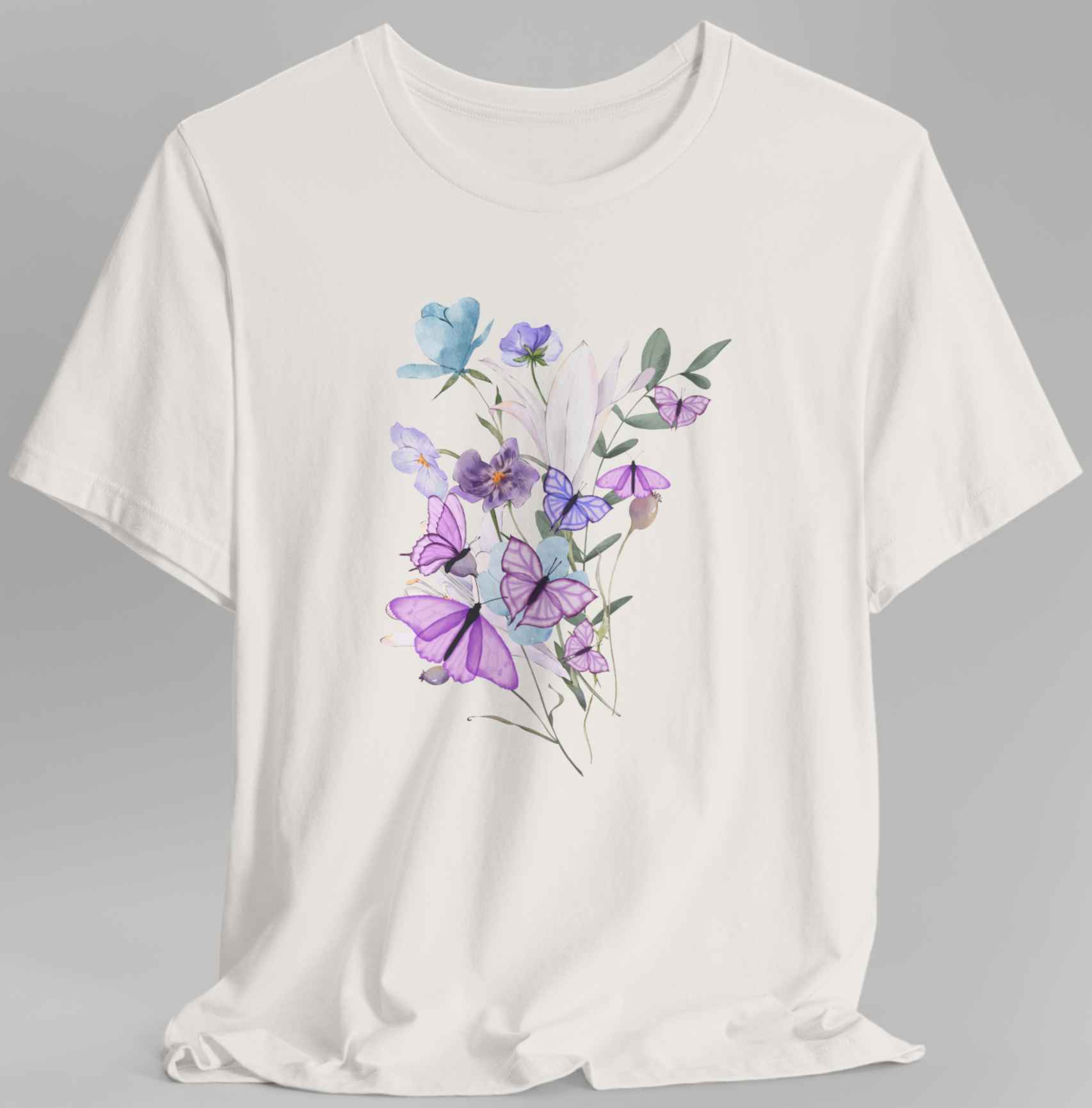 flowers and butterflies printed in a beige t-shirt in the gray background