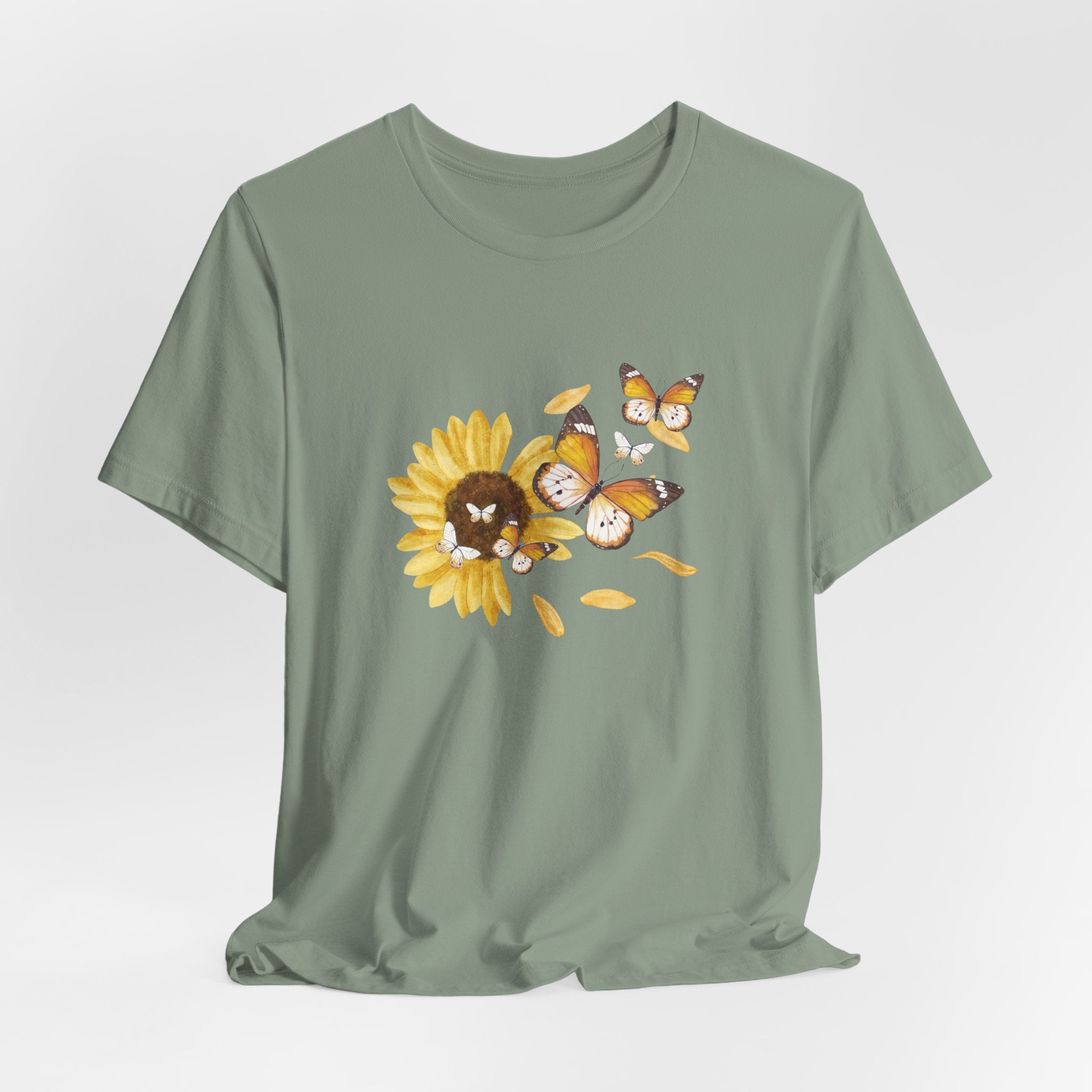 Green t-shirt with a sunflower and butterfly design on a light gray background