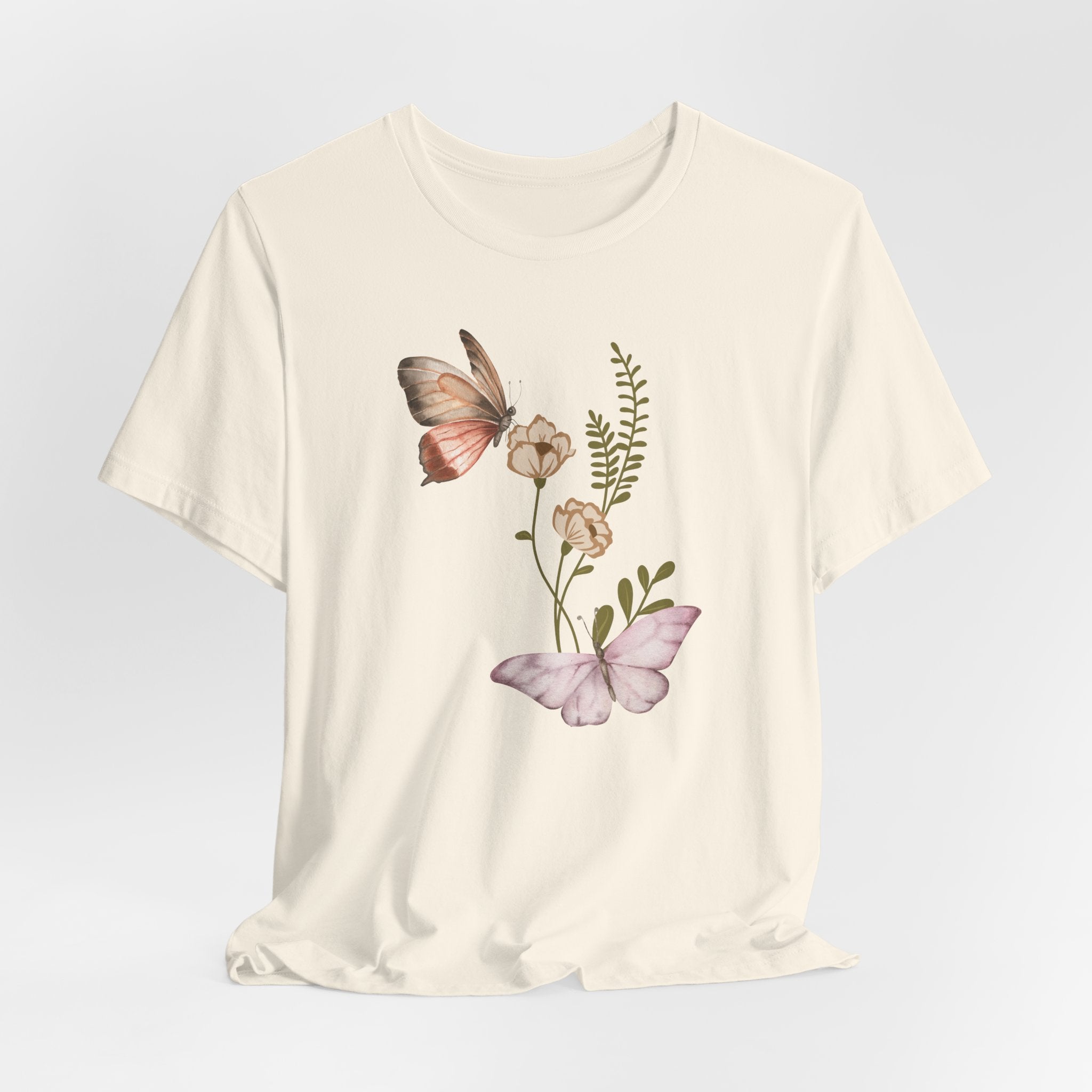 Beige t-shirt with butterfly and floral design on a light gray background