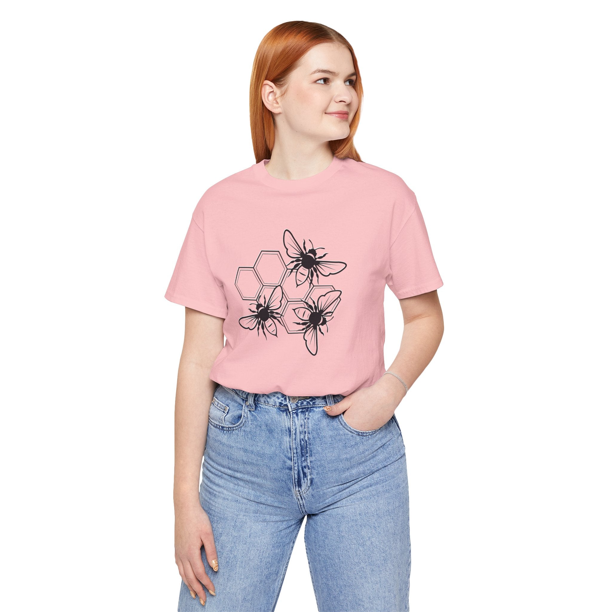 Person wearing a pink t-shirt with black floral designs on a white background
