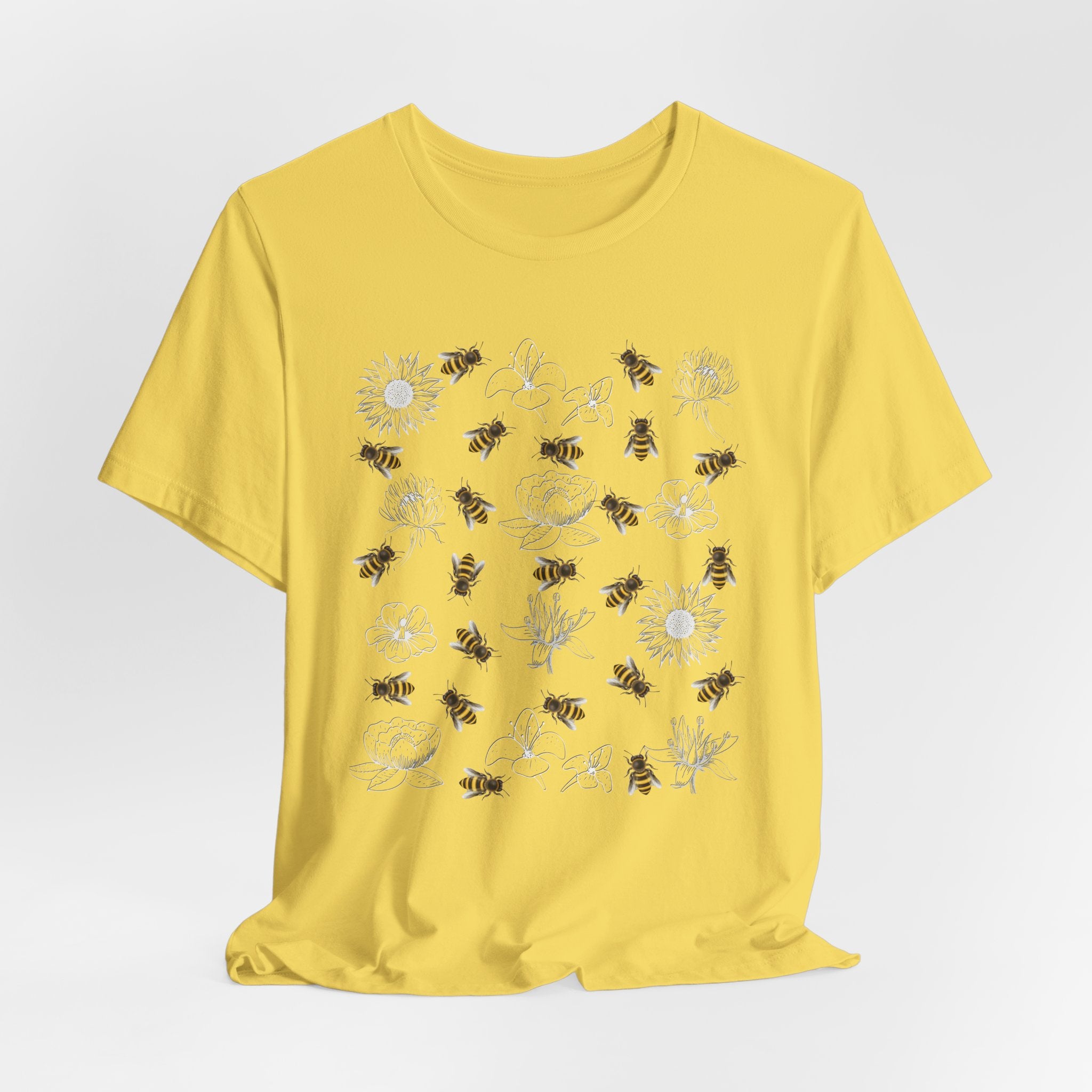 Yellow t-shirt with bee and flower pattern on a light gray background