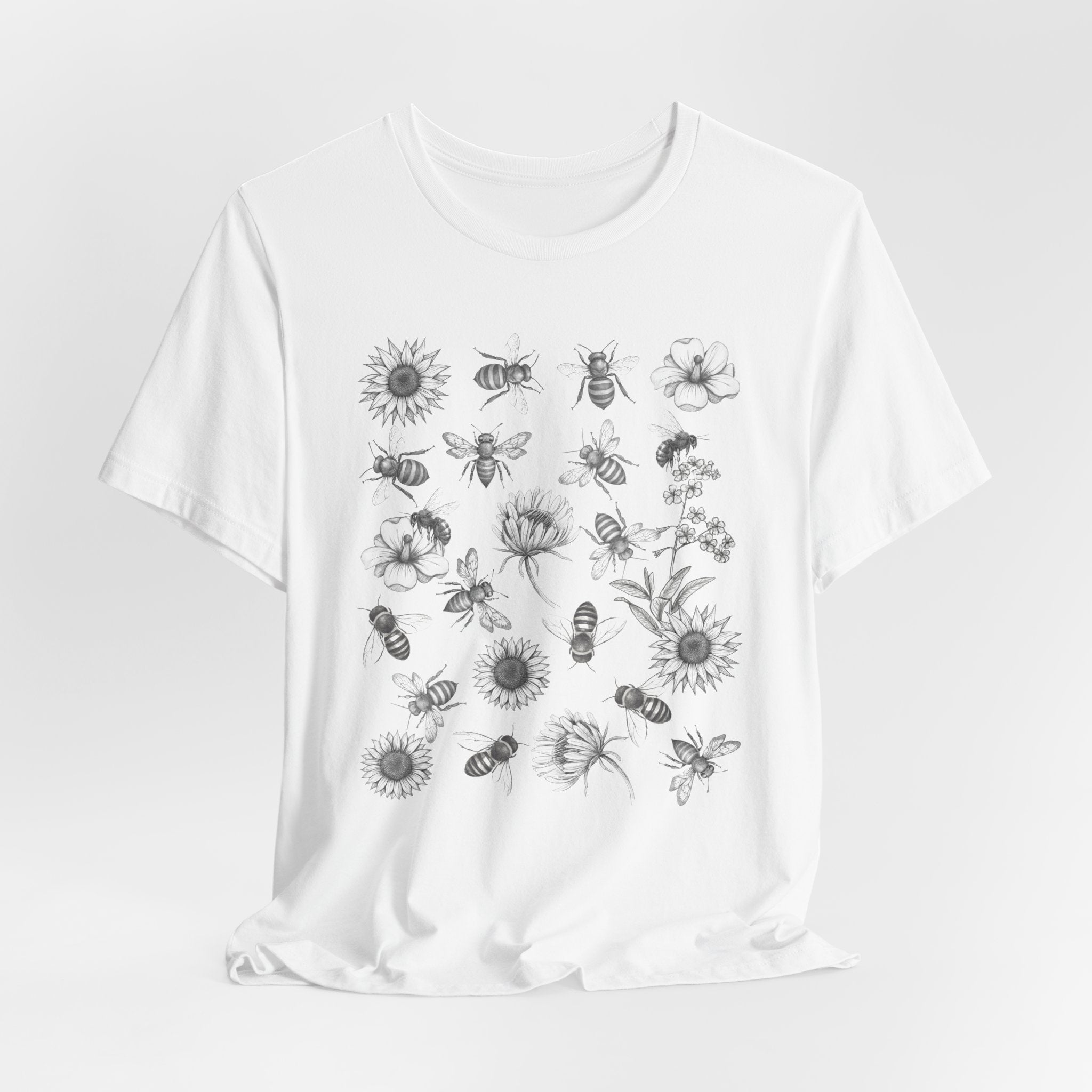 White t-shirt with black floral and bee pattern on a white background