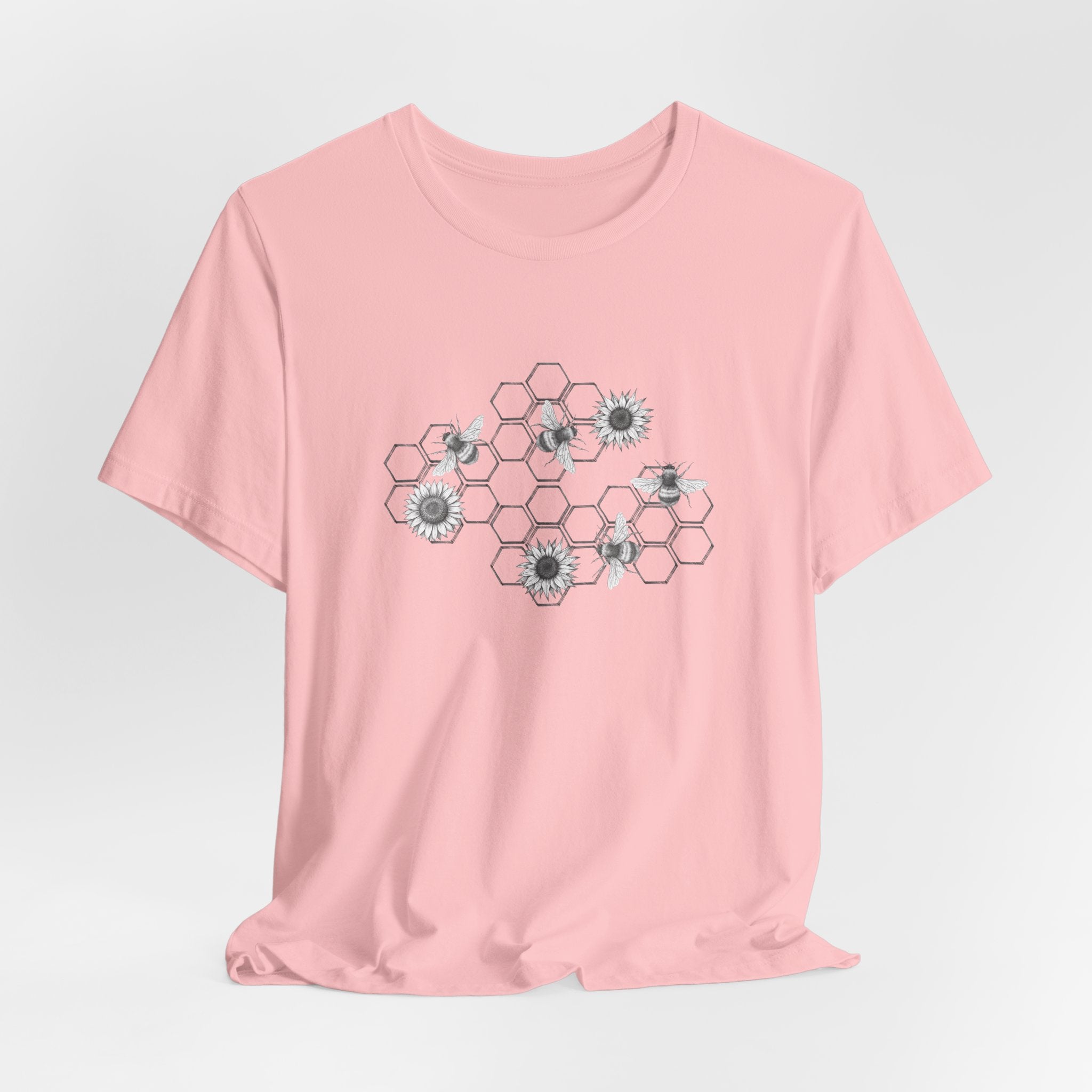 Pink t-shirt with floral hexagon pattern on a light gray background