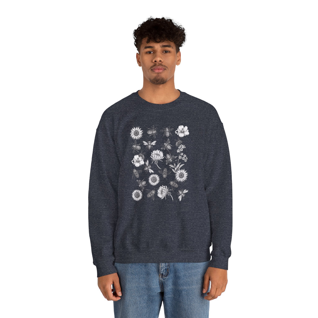 Person wearing a navy blue sweatshirt with bee and flower pattern on a white background