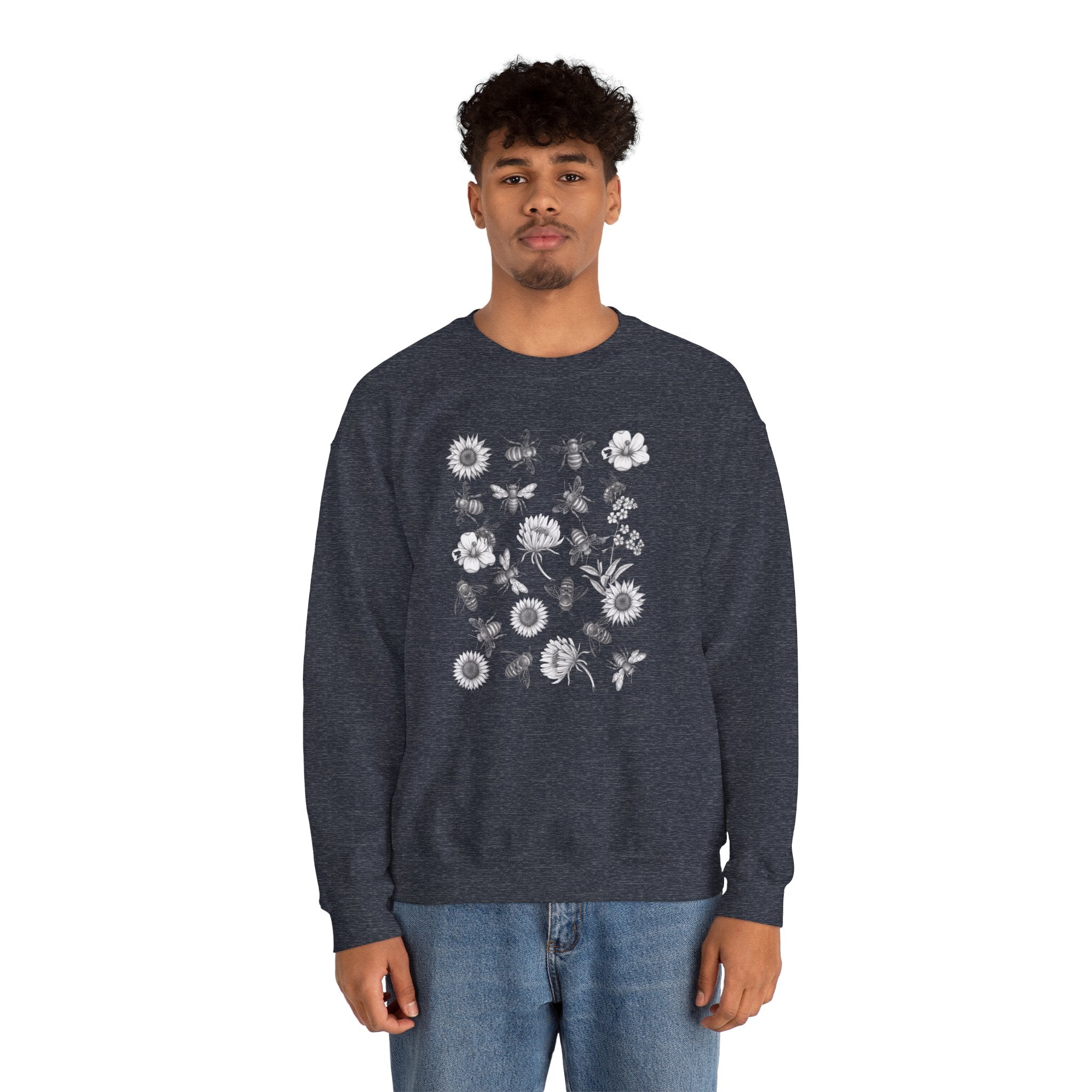 Person wearing a navy blue sweatshirt with bee and flower pattern on a white background