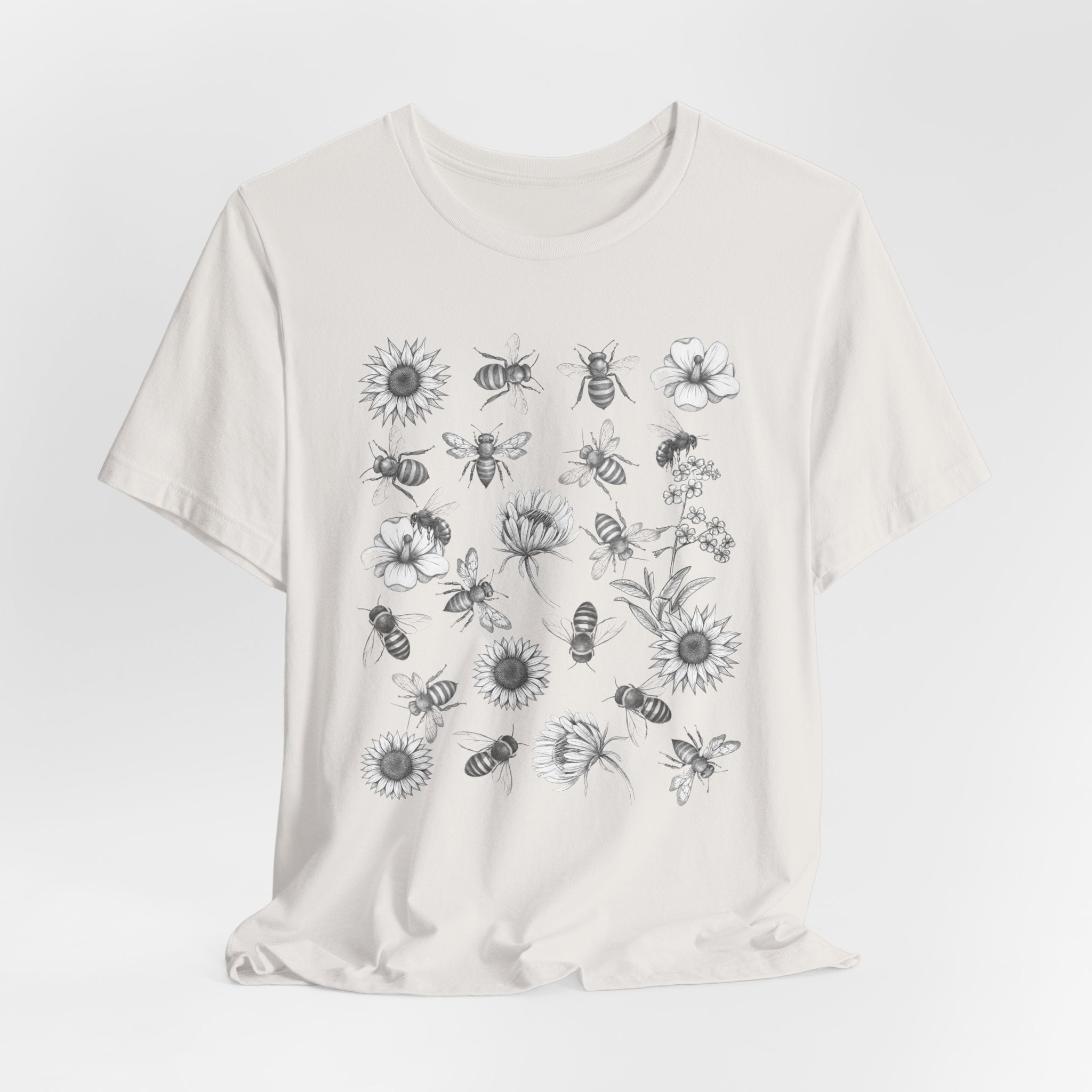 White t-shirt with black floral and bee pattern on a white background