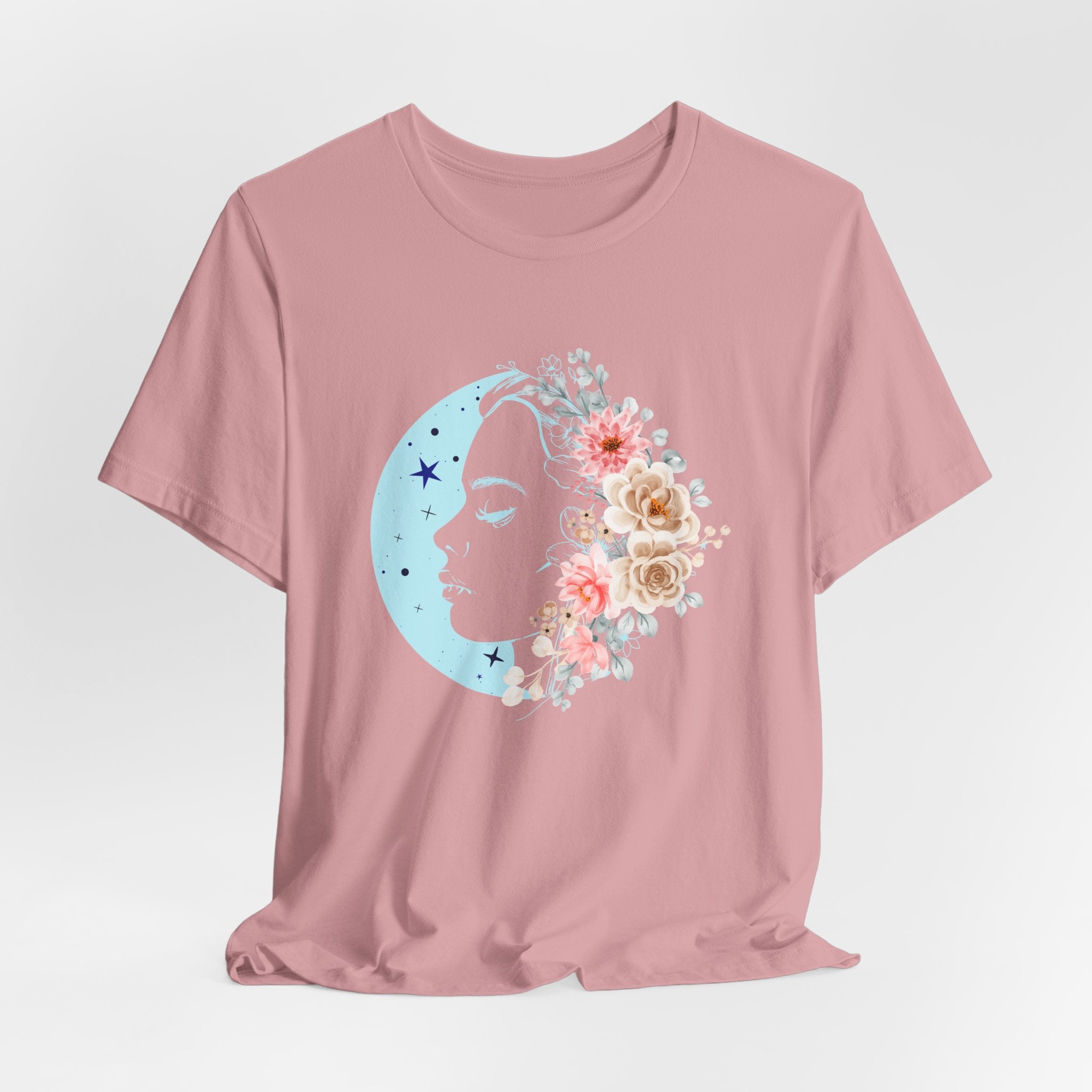 Pink t-shirt with a floral moon and star design on a light gray background