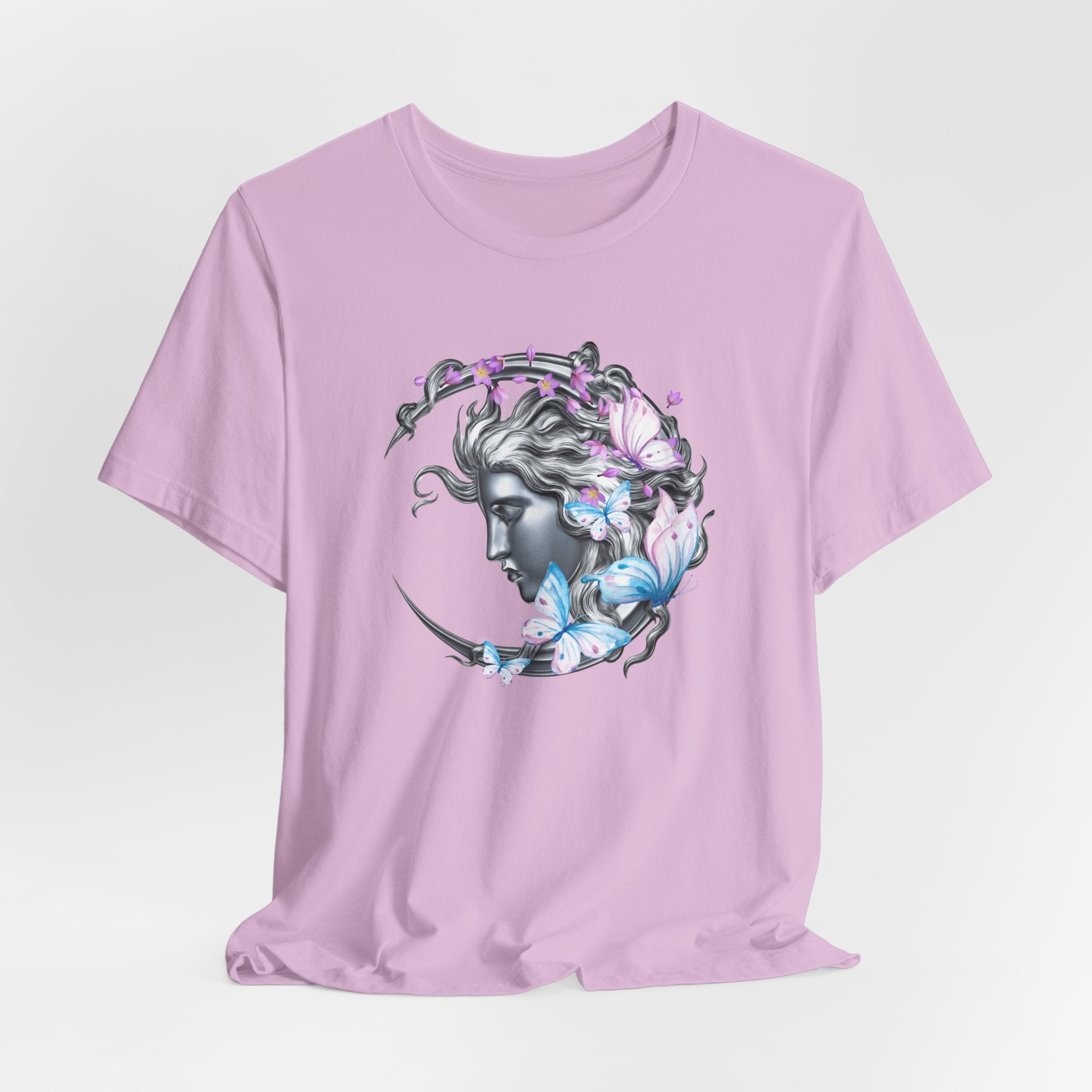 Pink t-shirt with a graphic design of a face surrounded by butterflies on a light purple background