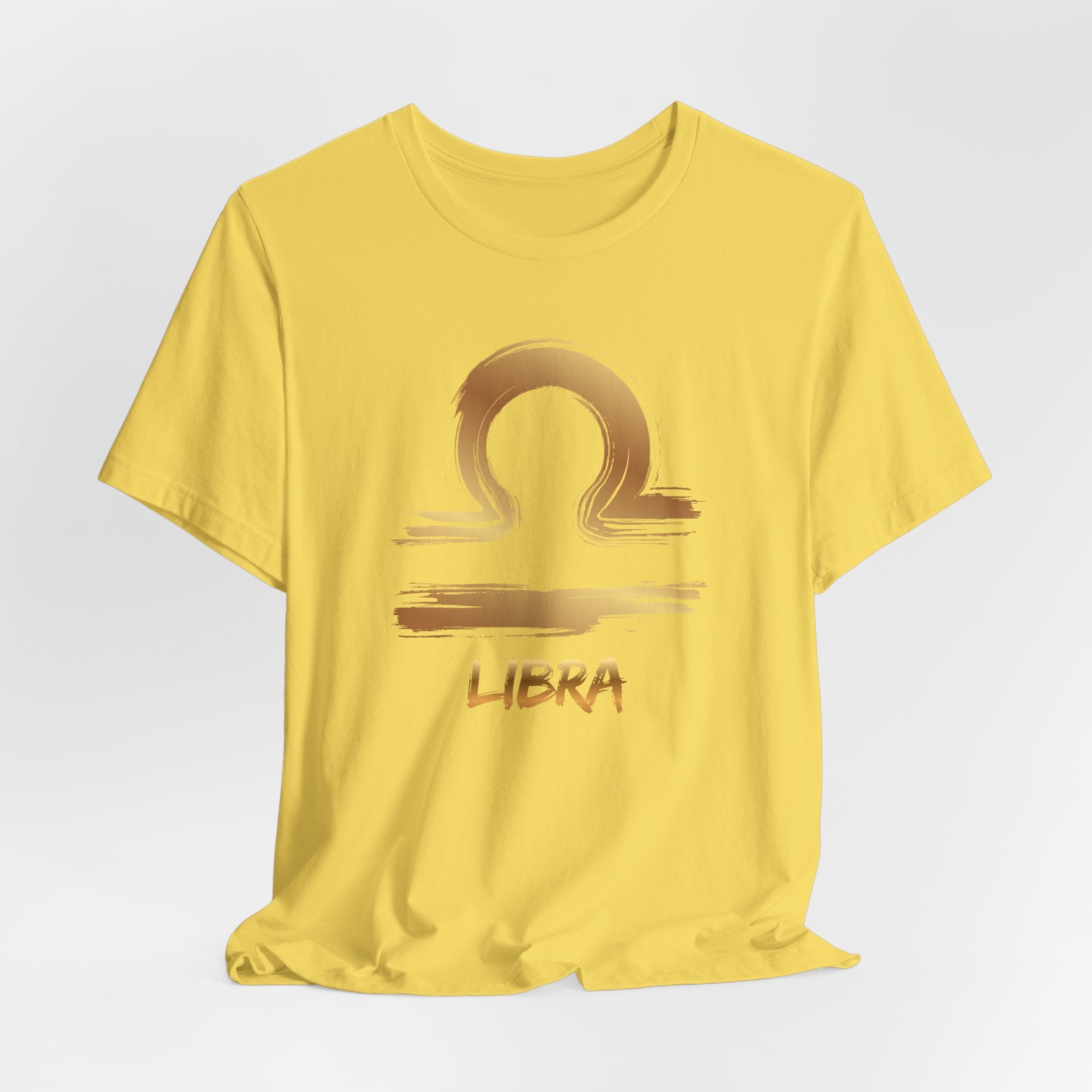 Yellow t-shirt with Libra zodiac symbol on a light gray background
