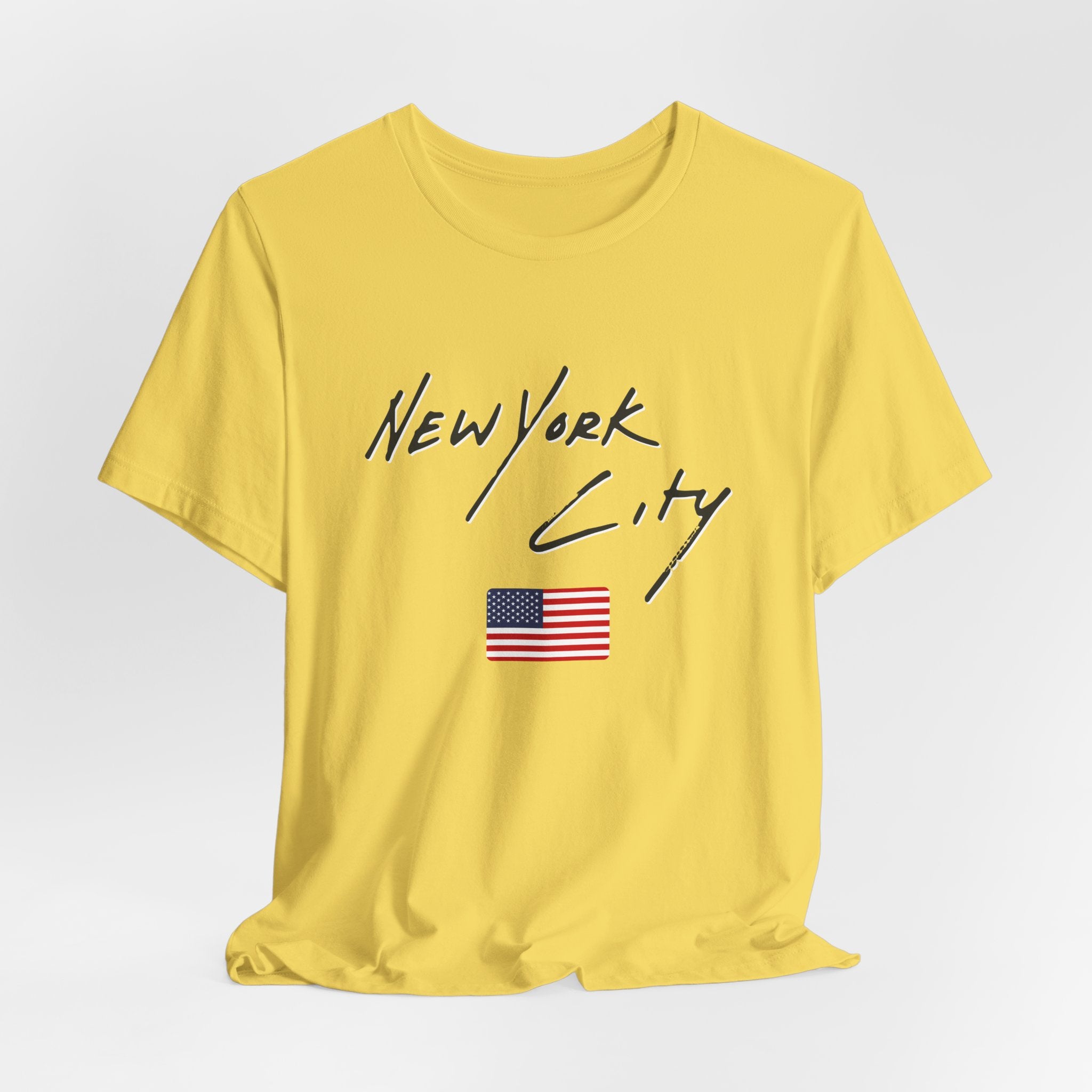 Yellow t-shirt with 'New York City' and American flag design on a light gray background