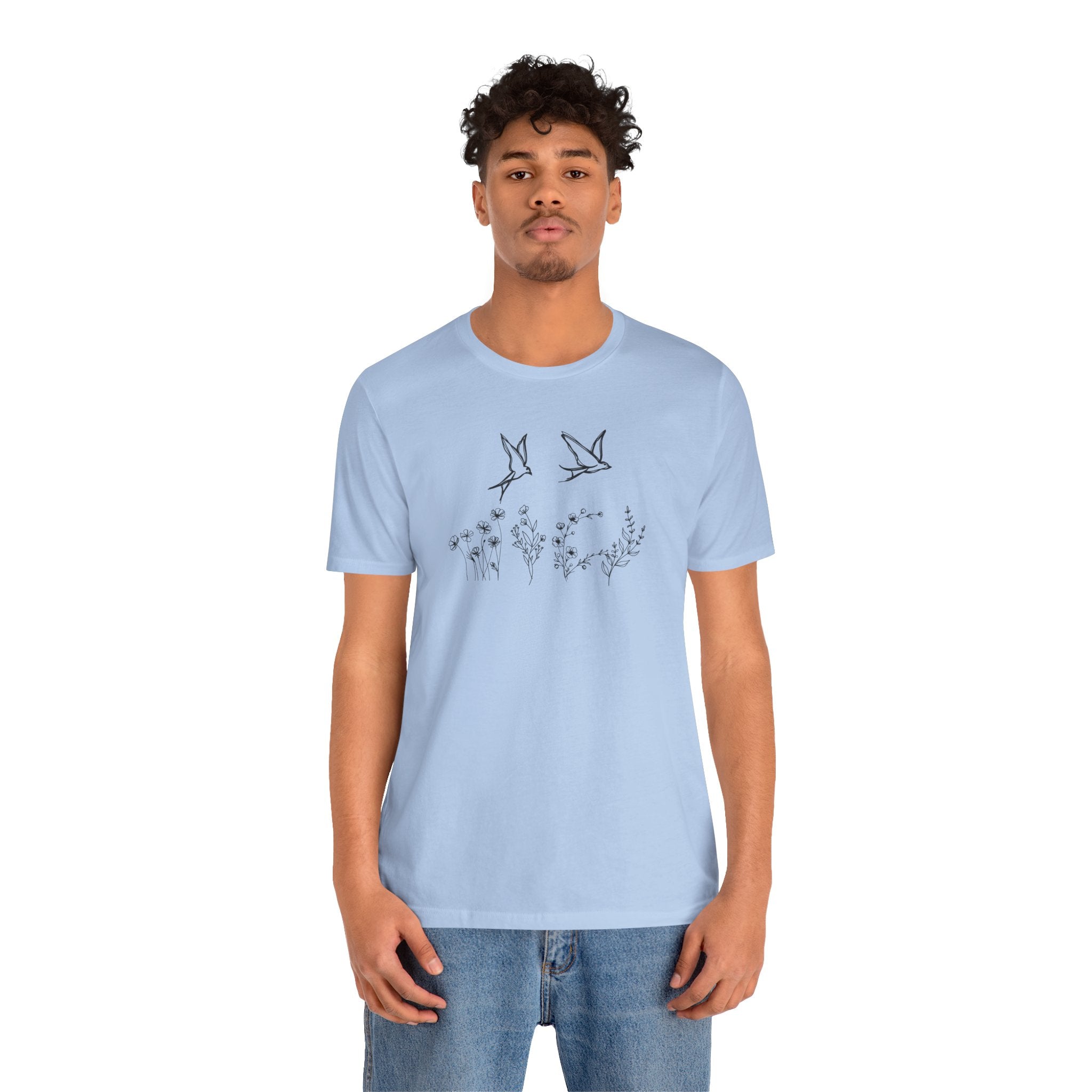Man wearing a light blue t-shirt with a graphic design on a white background