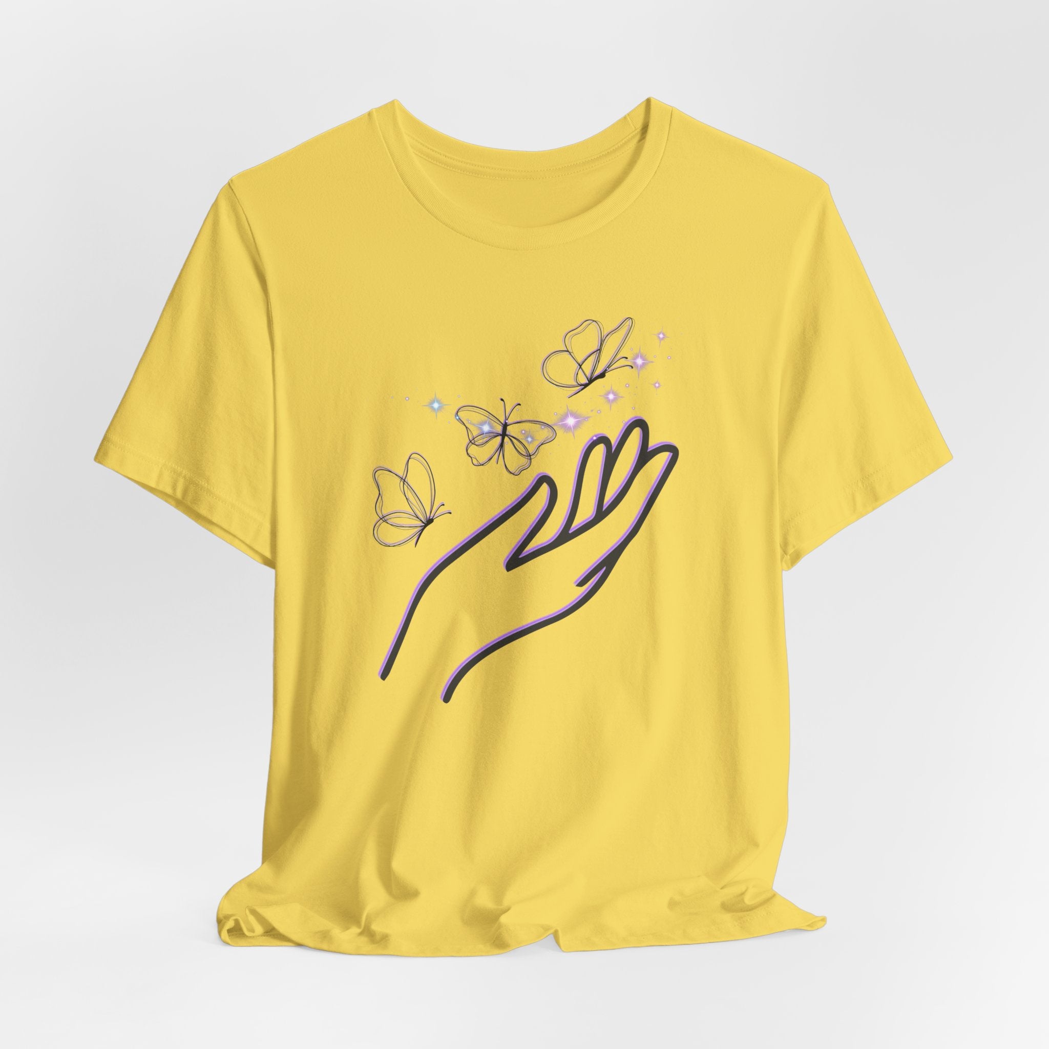 Yellow t-shirt with a design of a hand and butterflies on a light gray background