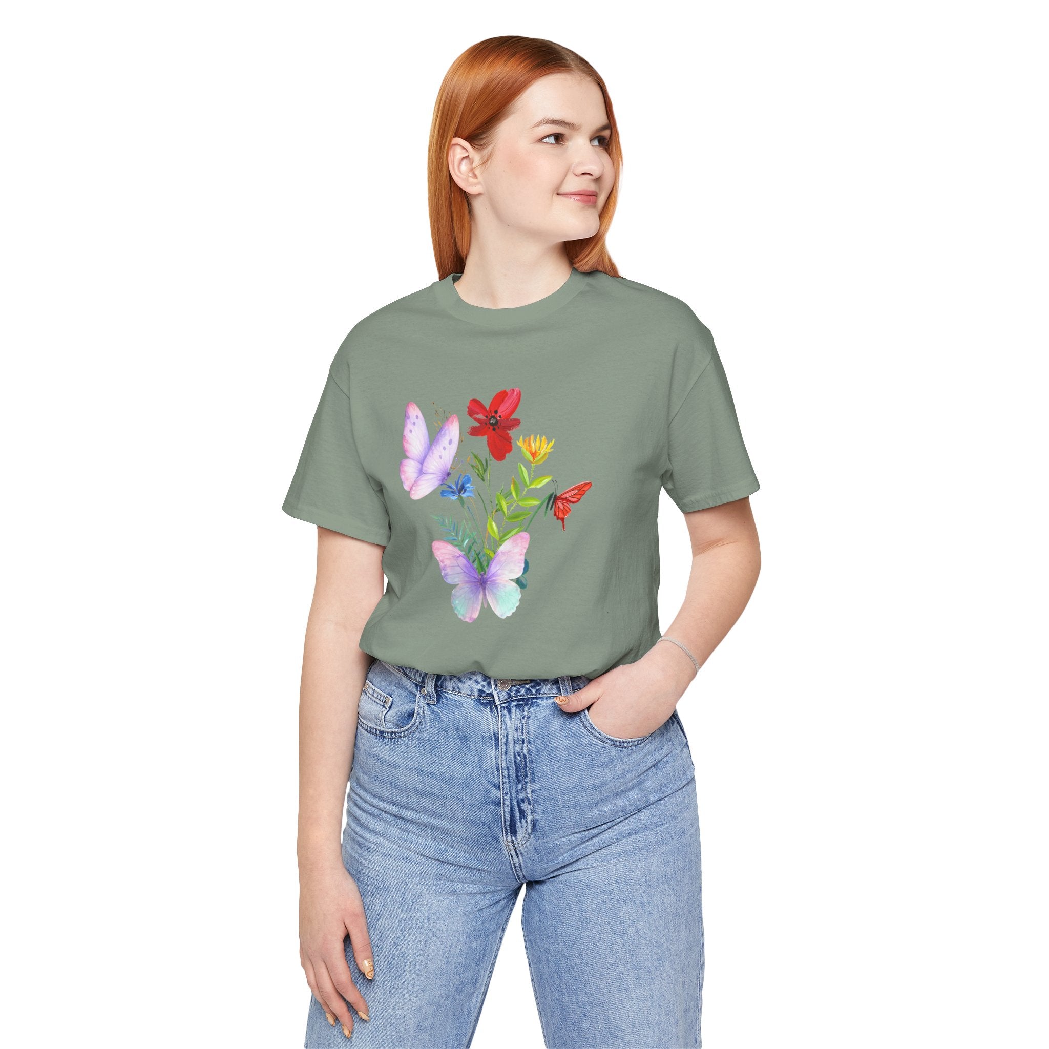 Person wearing a green t-shirt with butterfly design on a white background