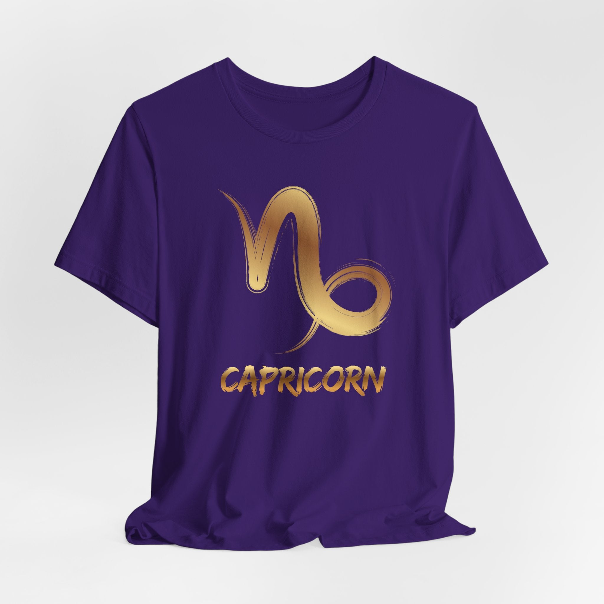 Purple t-shirt with gold Capricorn symbol and text on a white background