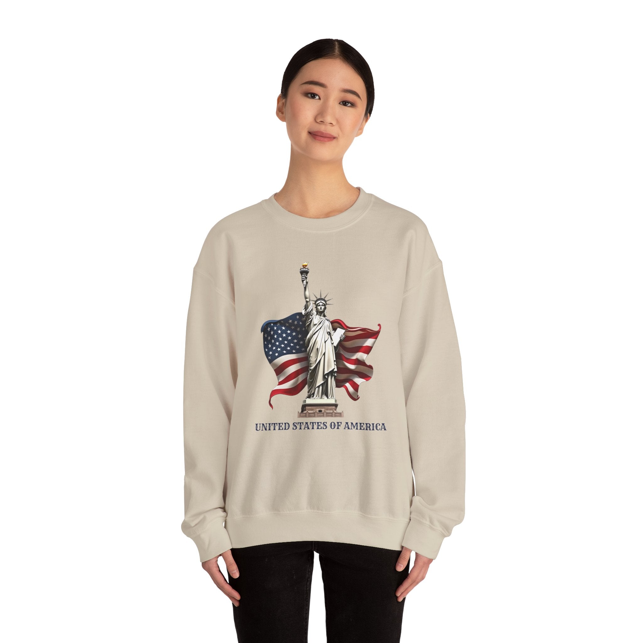 Person wearing a beige sweatshirt with Statue of Liberty and American flag design on a white background