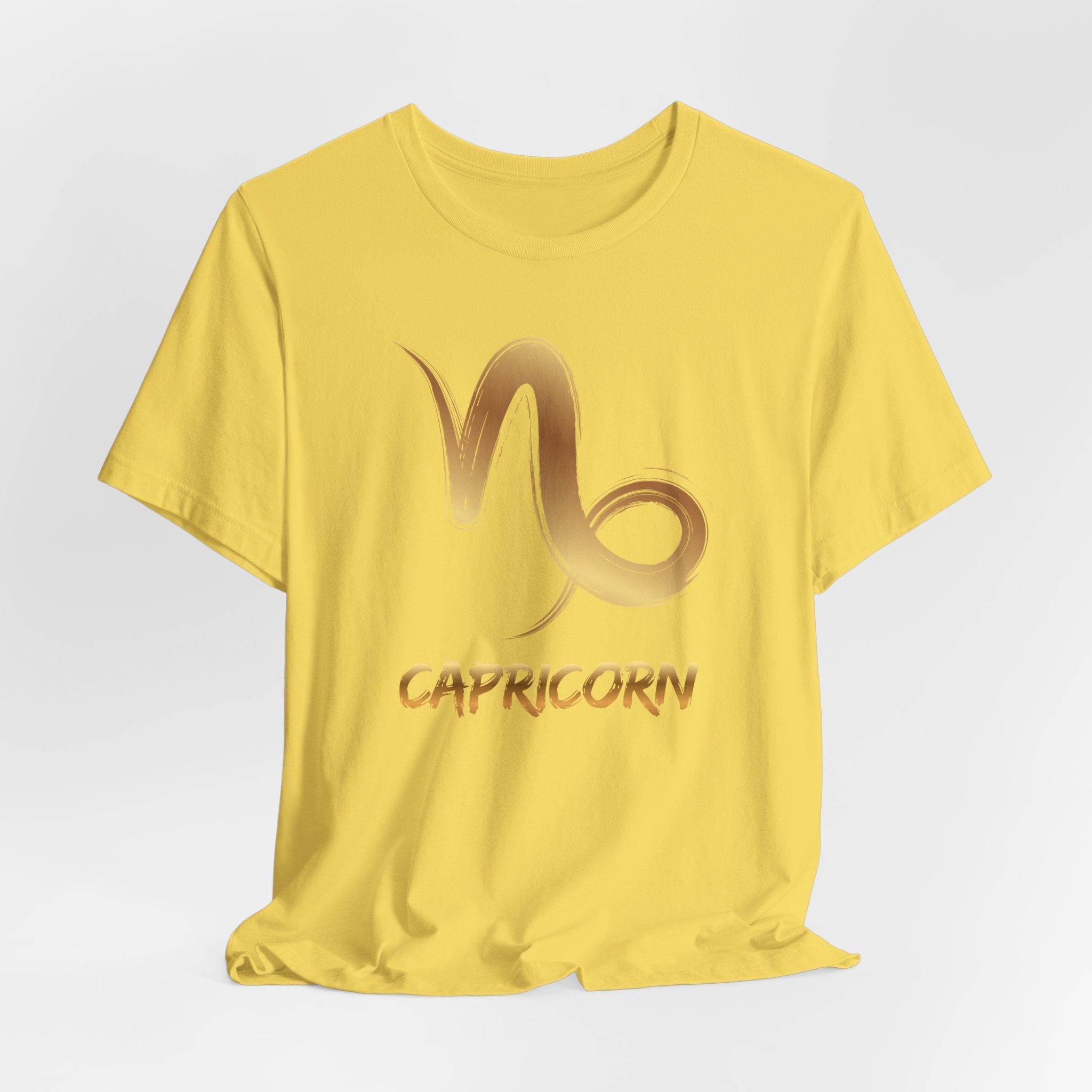 Yellow t-shirt with Capricorn zodiac sign design on a light gray background