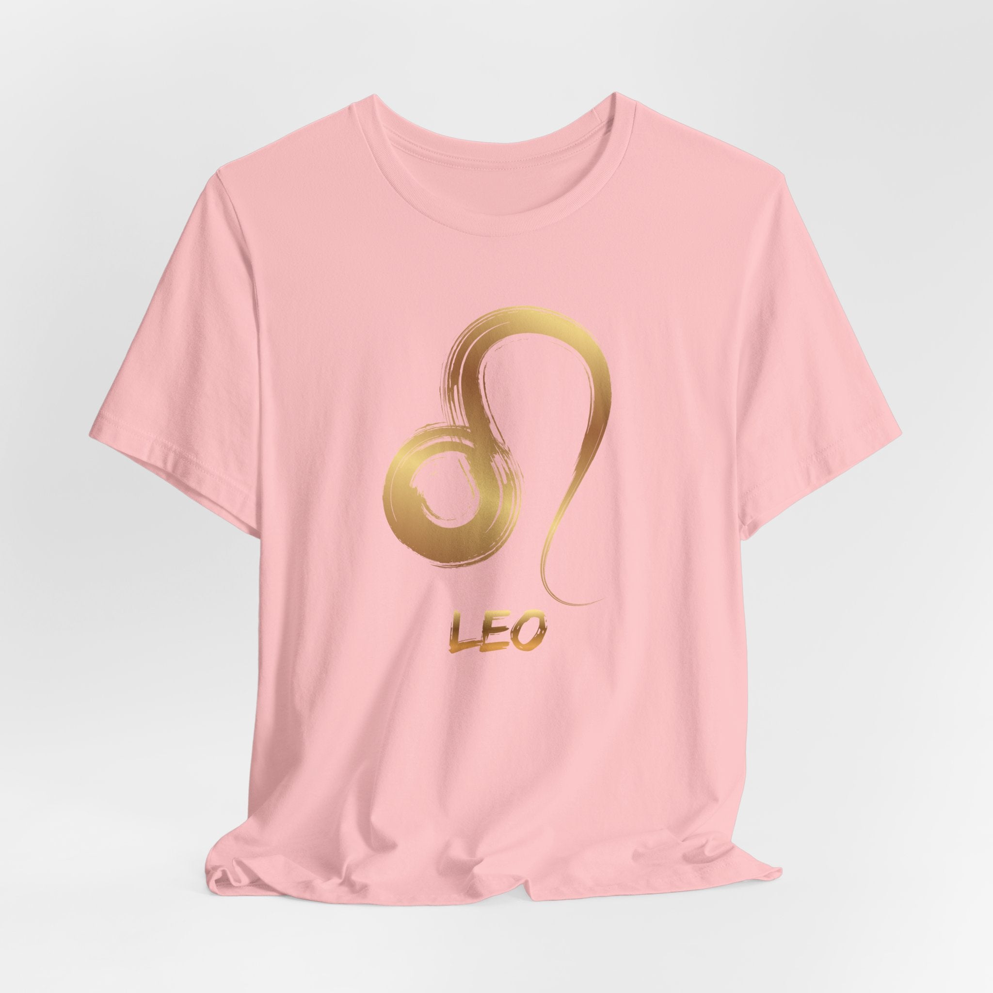 Pink t-shirt with gold Leo zodiac symbol on a light gray background