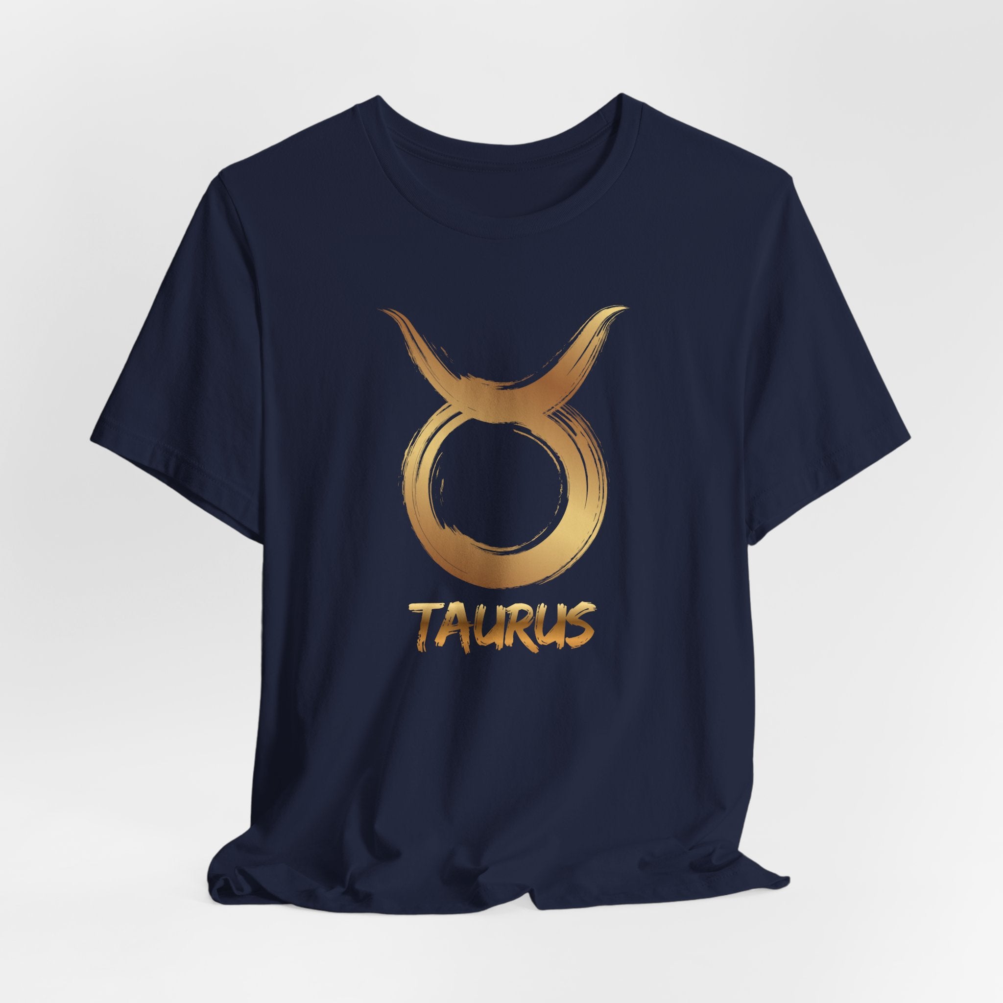 Navy blue t-shirt with gold Taurus zodiac symbol and text on a light gray background