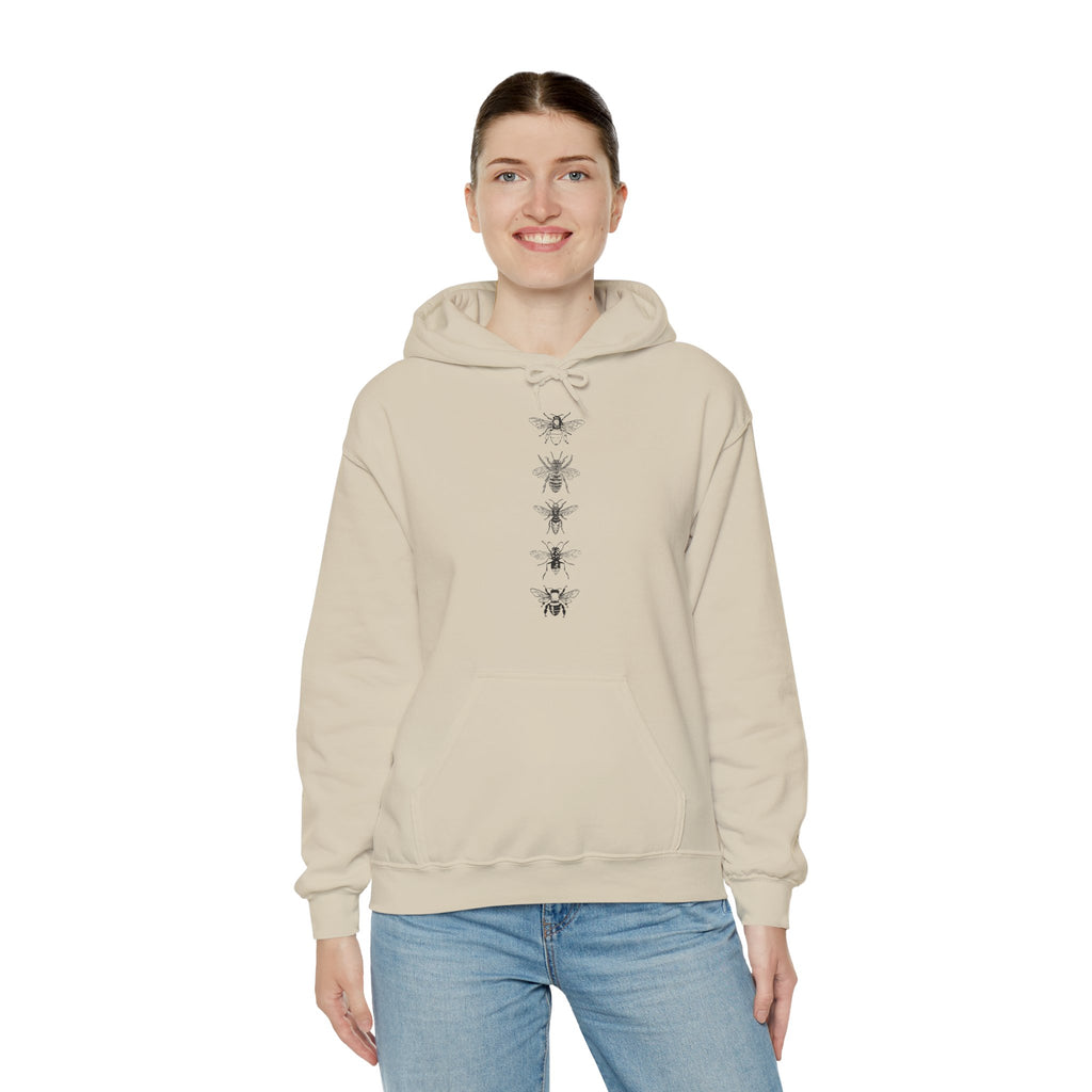 Person wearing a beige hoodie with a bee design on a white background
