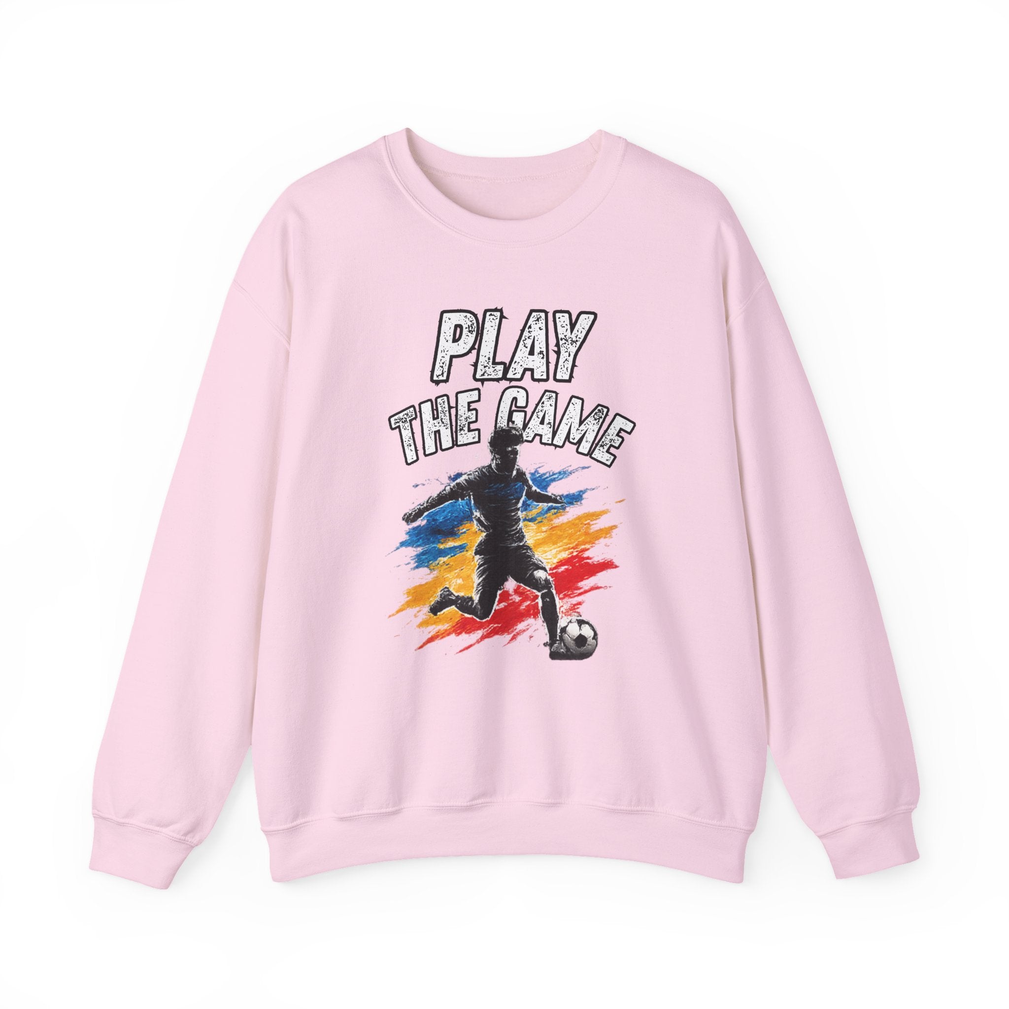 A light pink crewneck sweatshirt featuring a graphic print of a soccer player with the text 'PLAY THE GAME' and a colorful paint-splatter background.