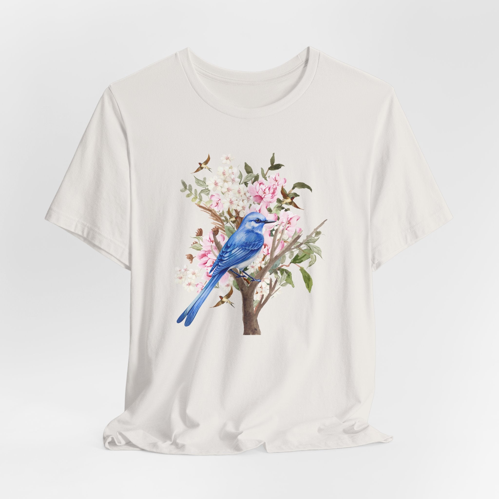White t-shirt with a blue bird and floral design on a white background