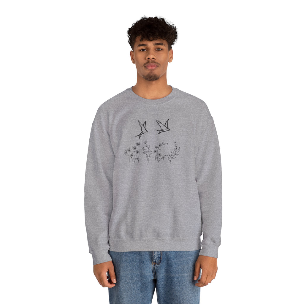 Person wearing a gray sweatshirt with bird and flower graphics on a white background