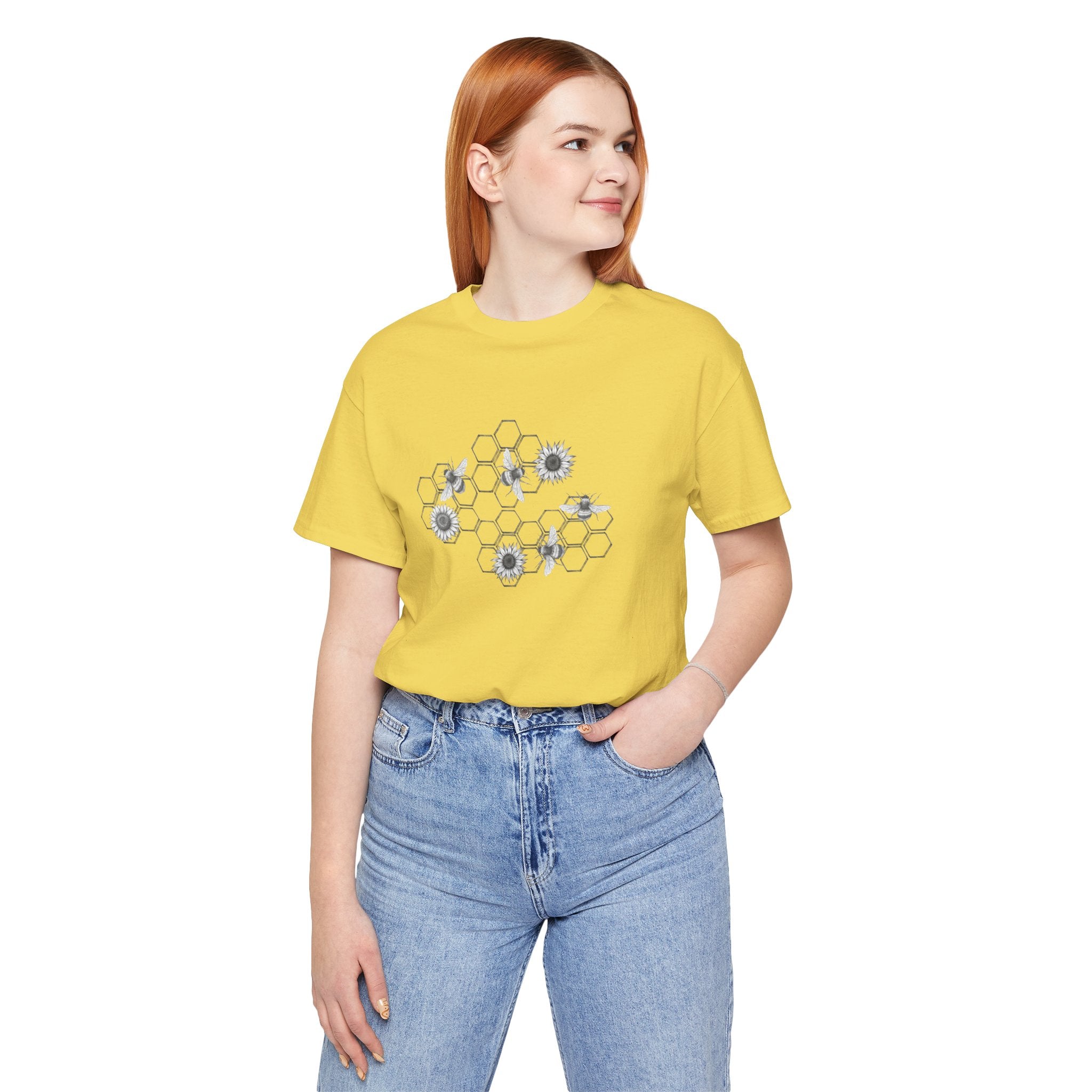 Person wearing a yellow t-shirt with a floral design and blue jeans on a white background