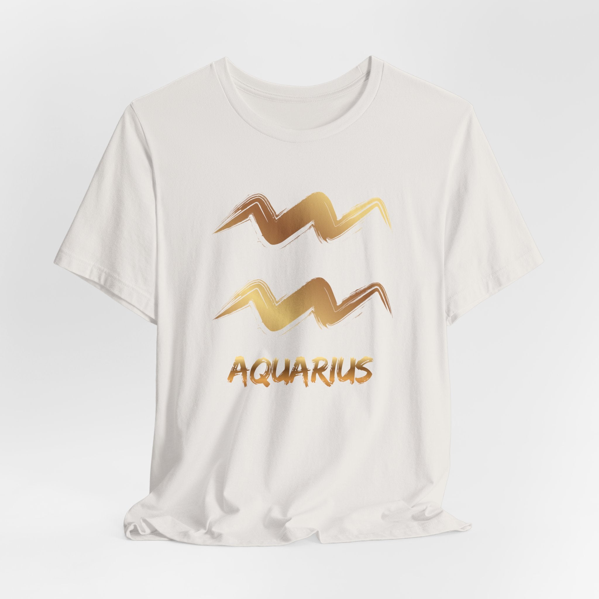 White t-shirt with gold Aquarius zodiac sign design on a light gray background