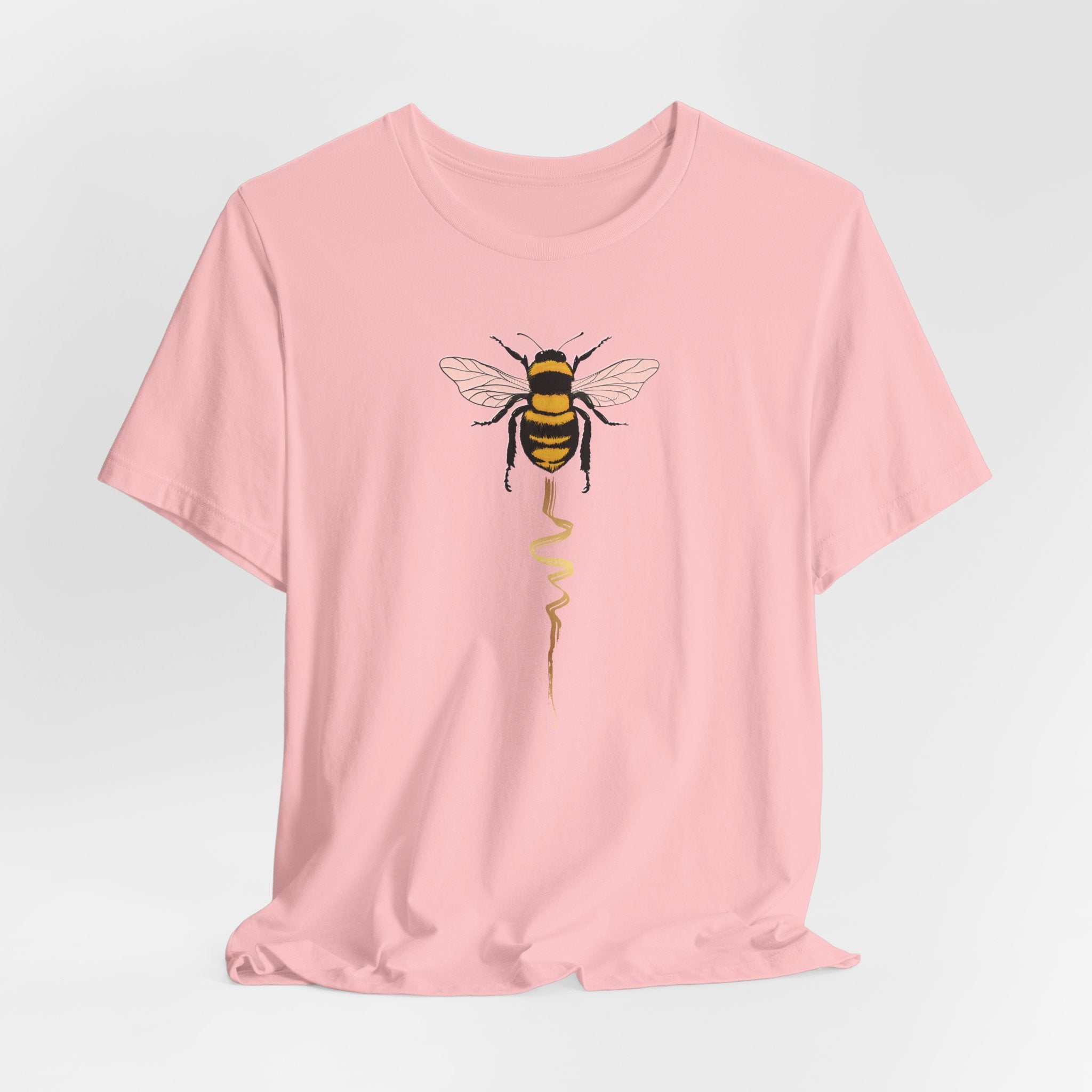 Pink t-shirt with a bee design on a light gray background