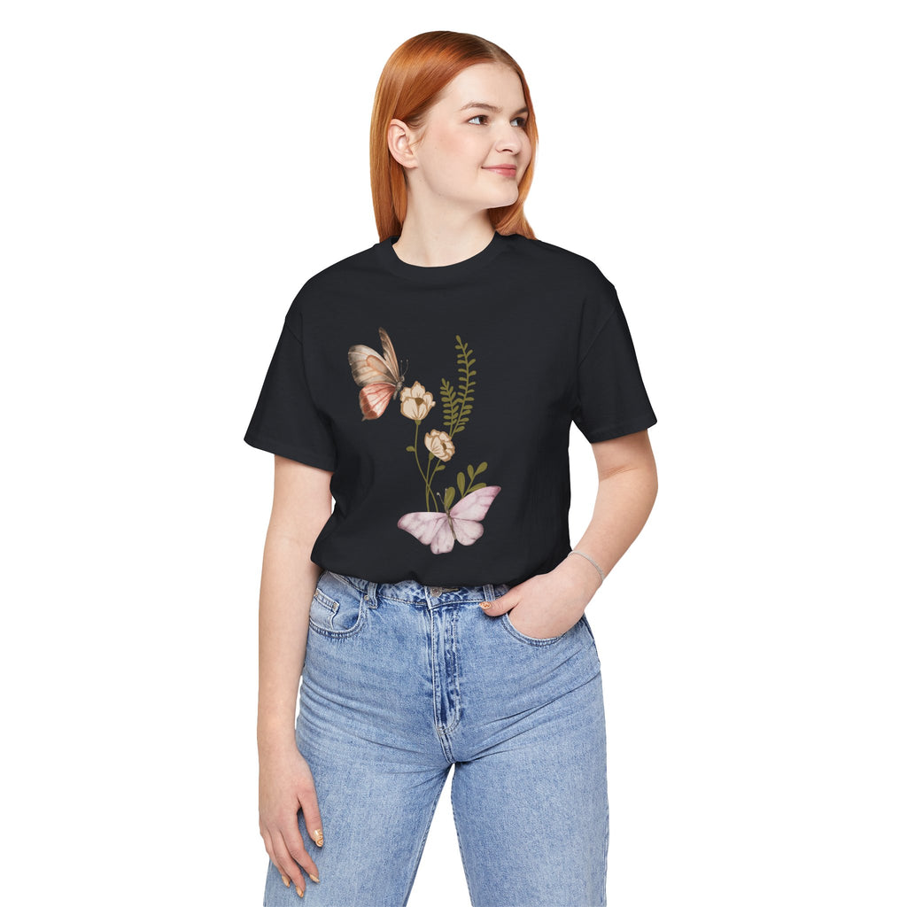 Person wearing a black t-shirt with butterfly and floral design on a white background