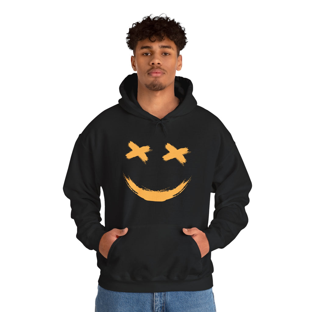 Person wearing a black hoodie with a yellow smiley face design on a white background