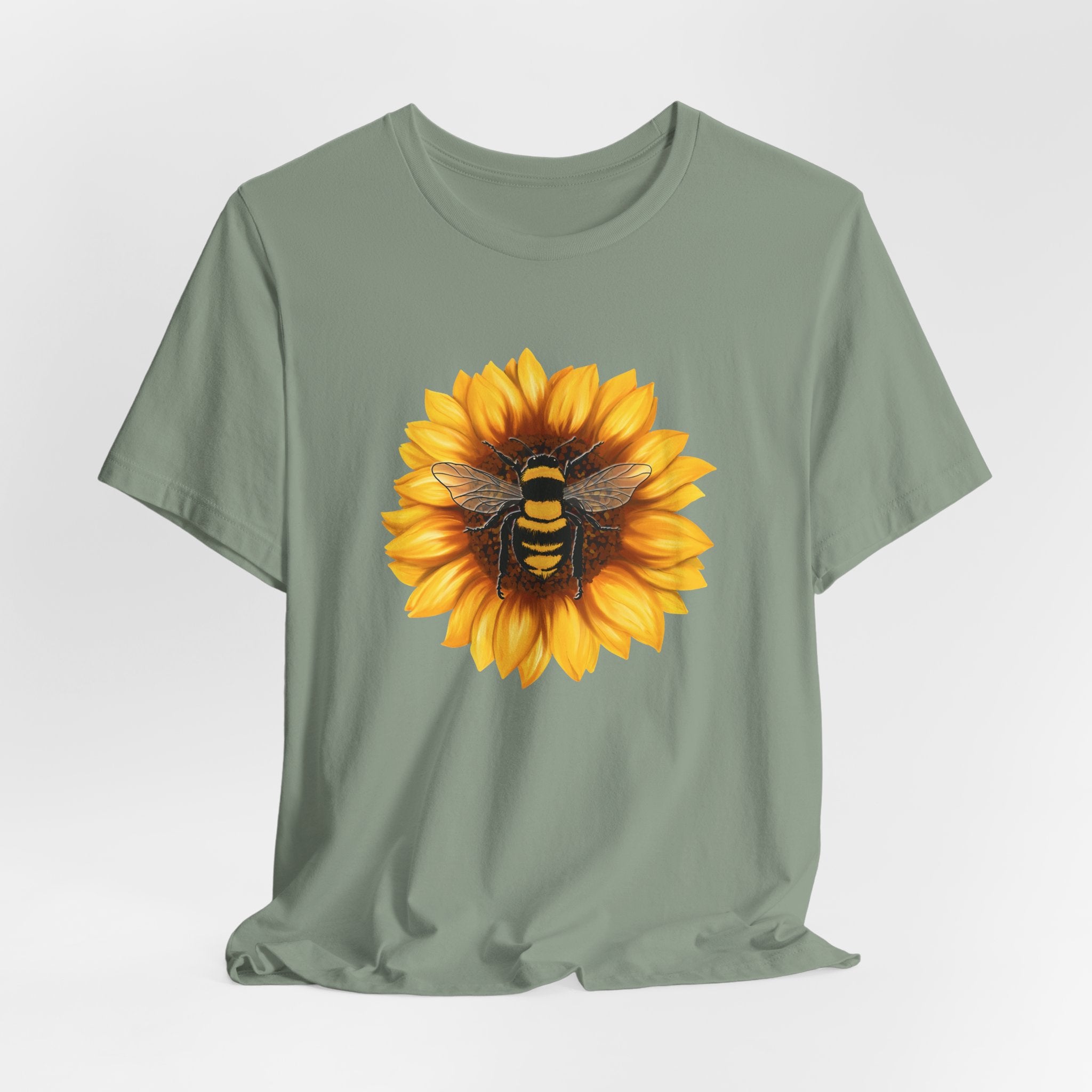 Green t-shirt with a sunflower and bee design on a light gray background