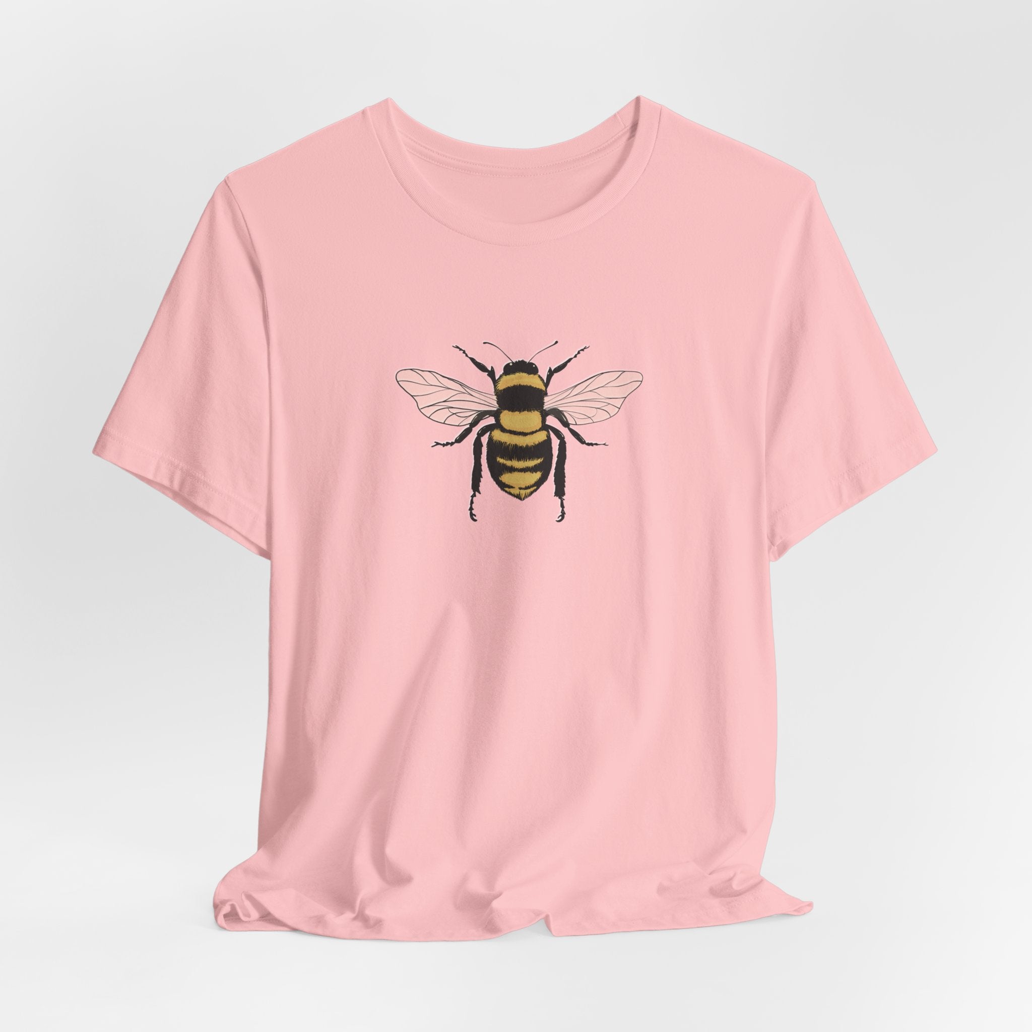 Pink t-shirt with a bee graphic on a light gray background