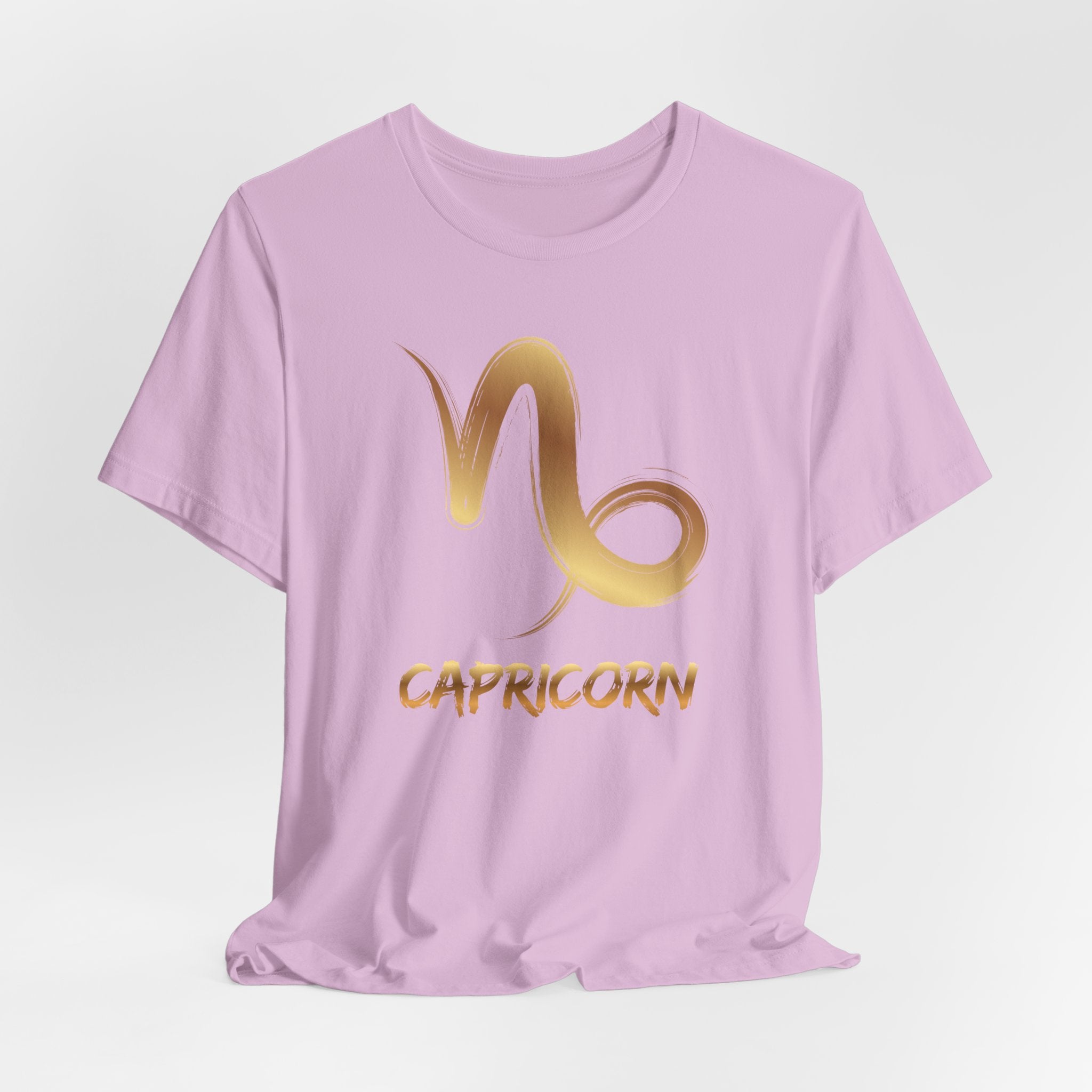 Lavender t-shirt with gold Capricorn symbol and text on a light gray background