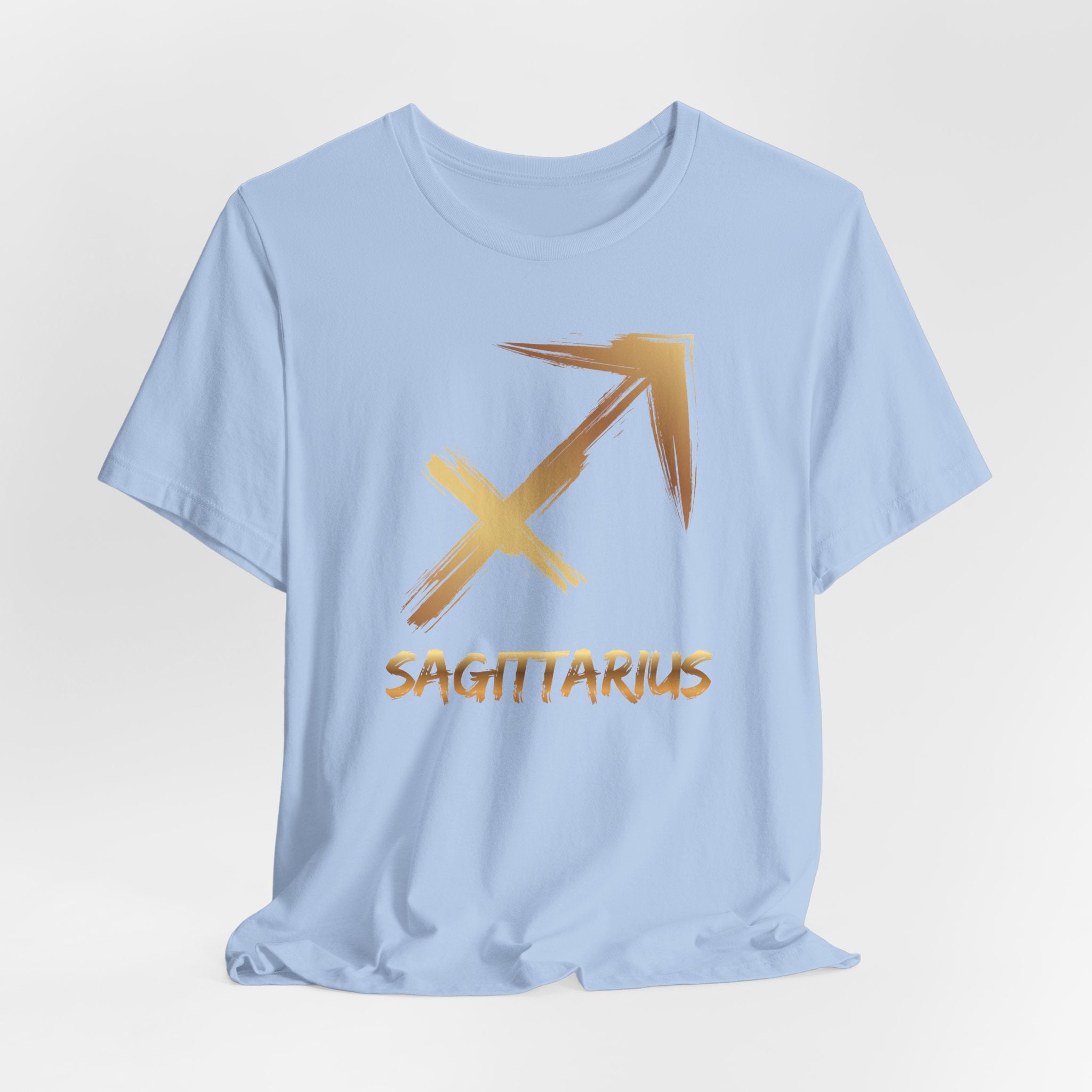 Light blue t-shirt with gold Sagittarius symbol and text on a light gray background