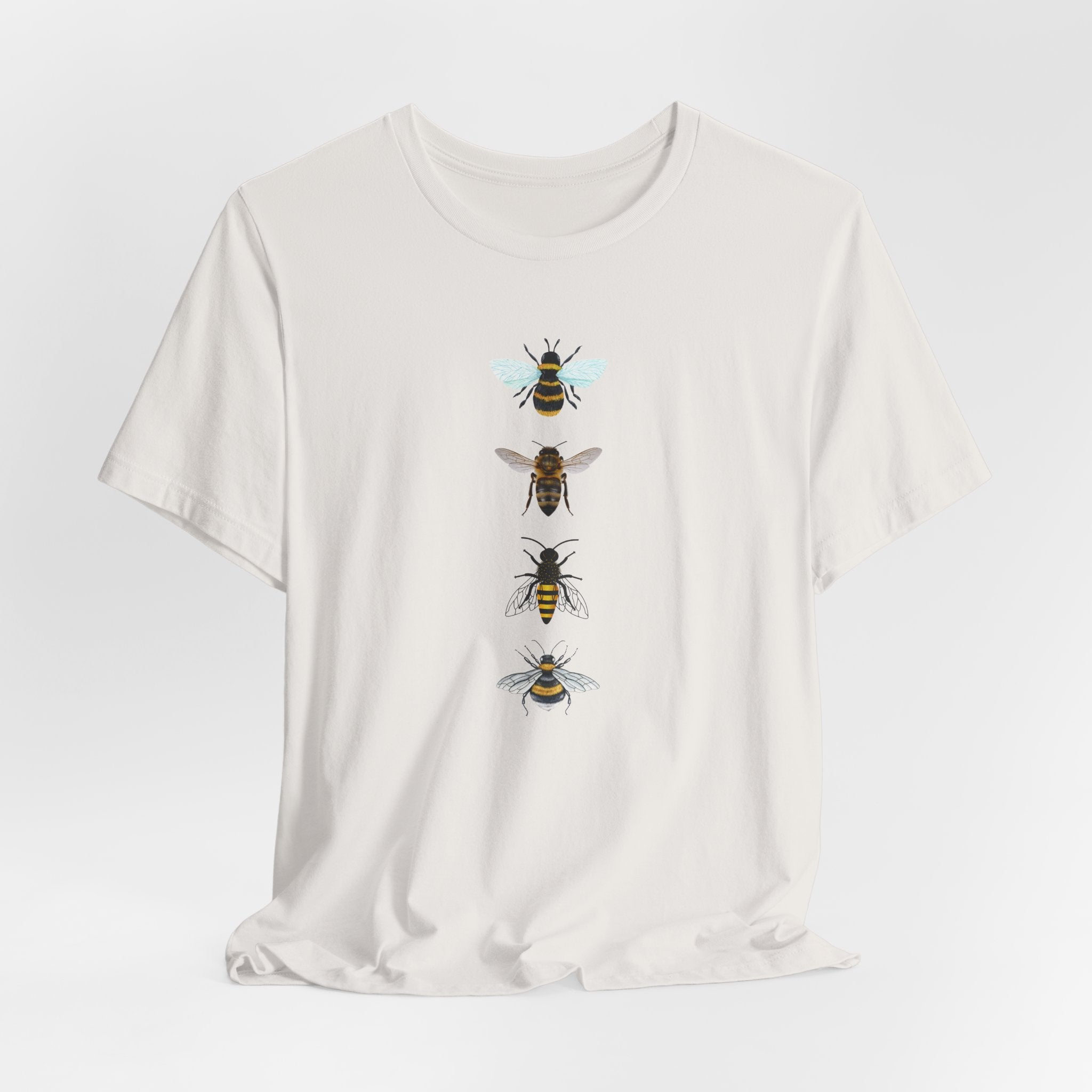 White t-shirt with bee illustrations on a light gray background