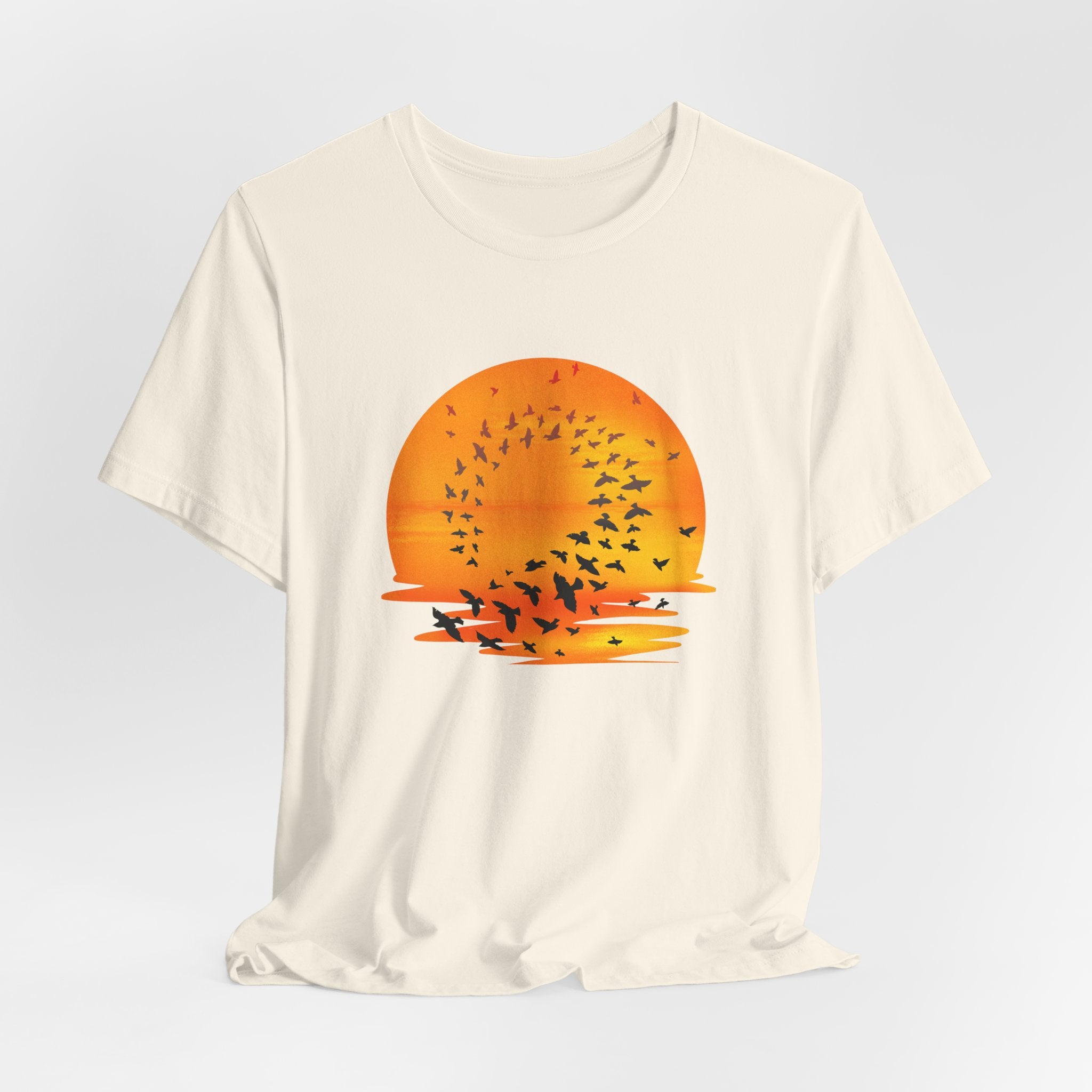 White t-shirt with a sunset and bird design on a light gray background