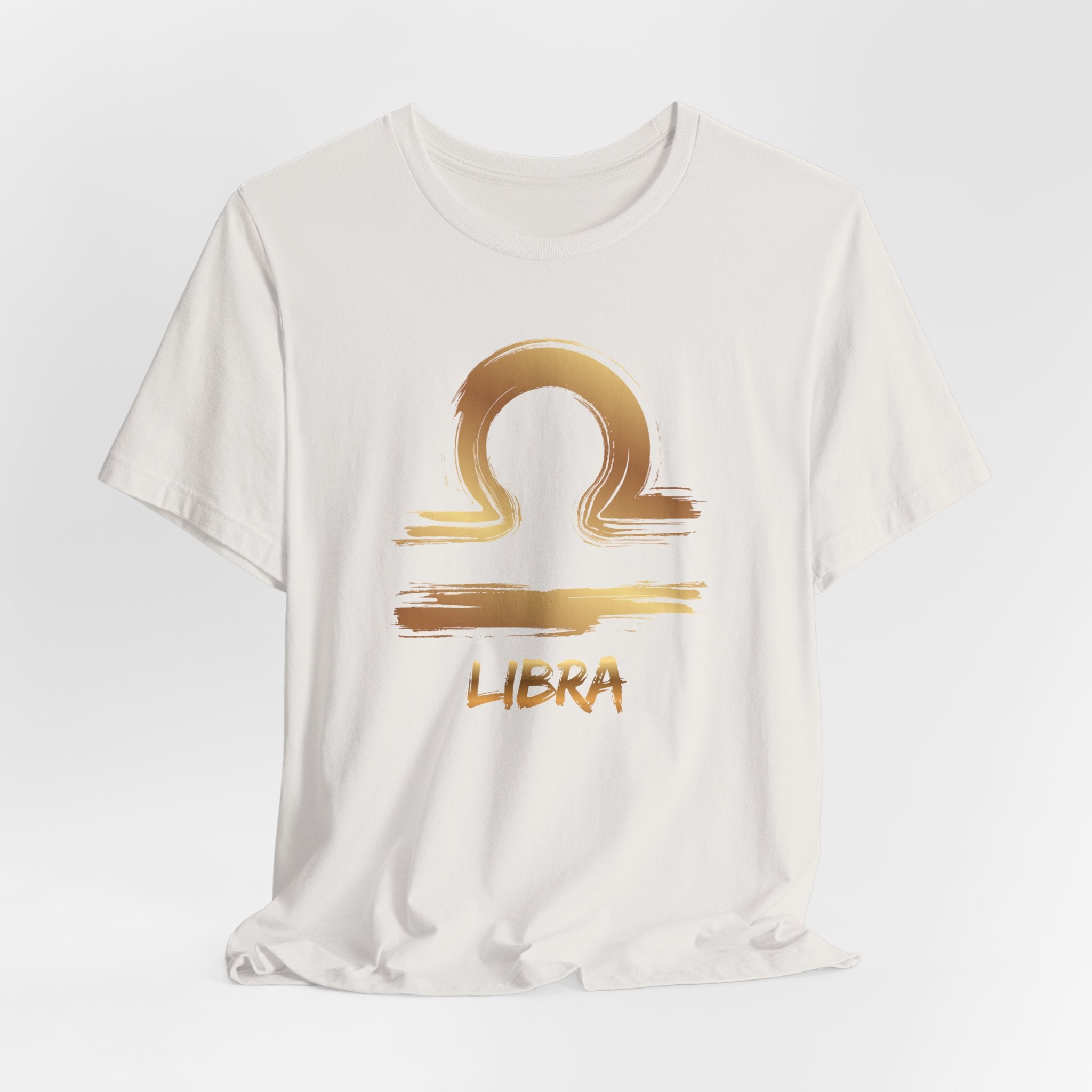 White t-shirt with gold Libra zodiac sign design on a light gray background