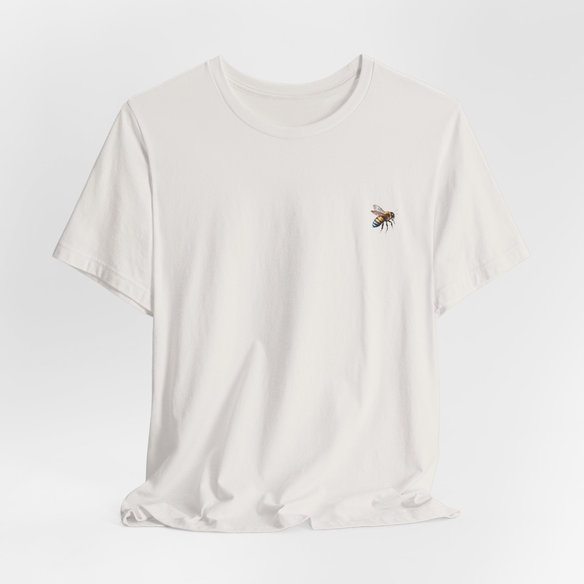 White t-shirt with a bee design on a light gray background