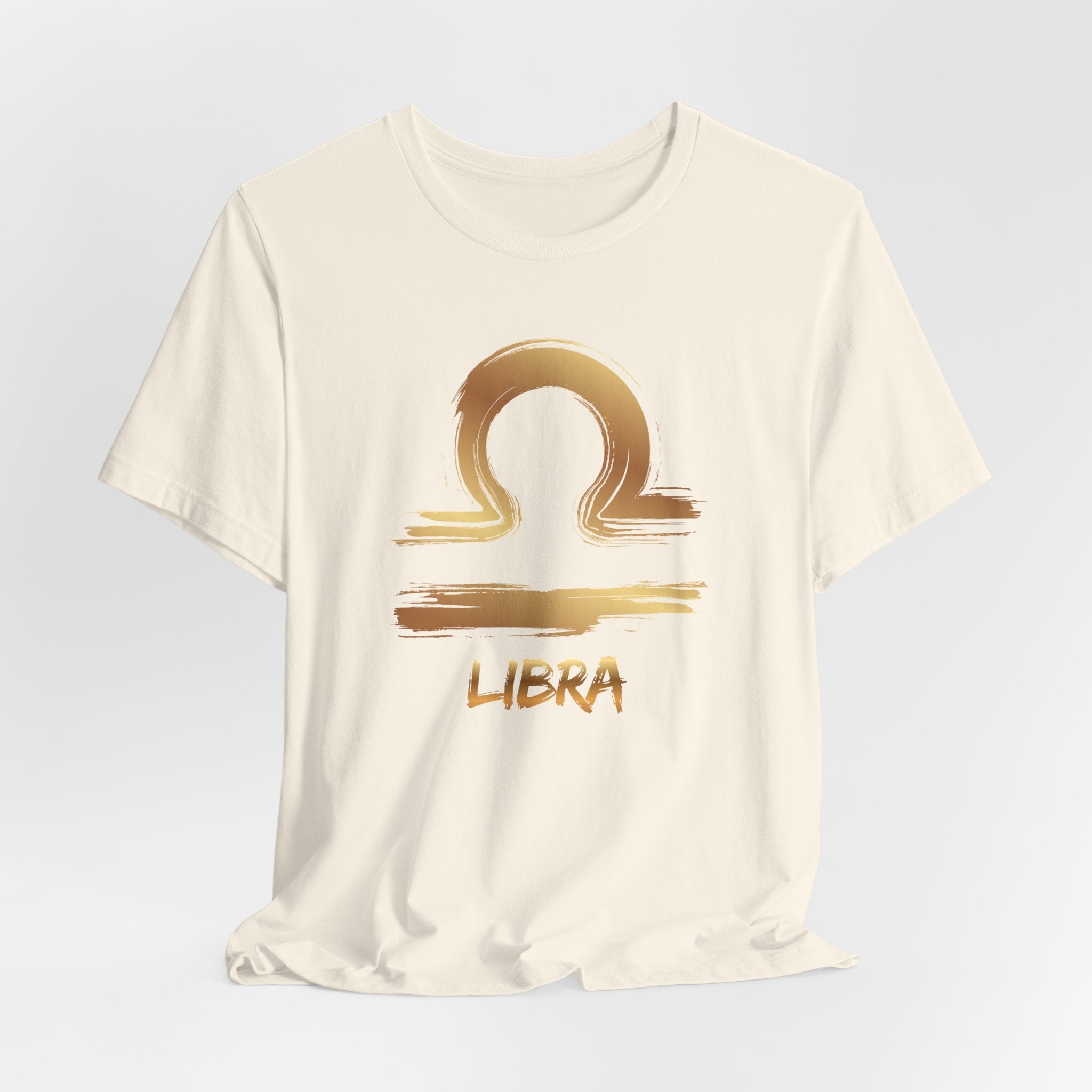 White t-shirt with gold Libra zodiac symbol on a light gray background