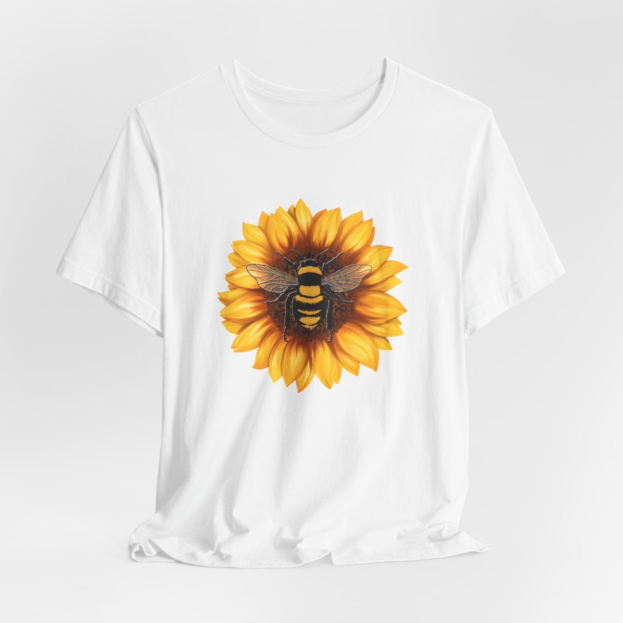 White t-shirt with a sunflower and bee design on a white background