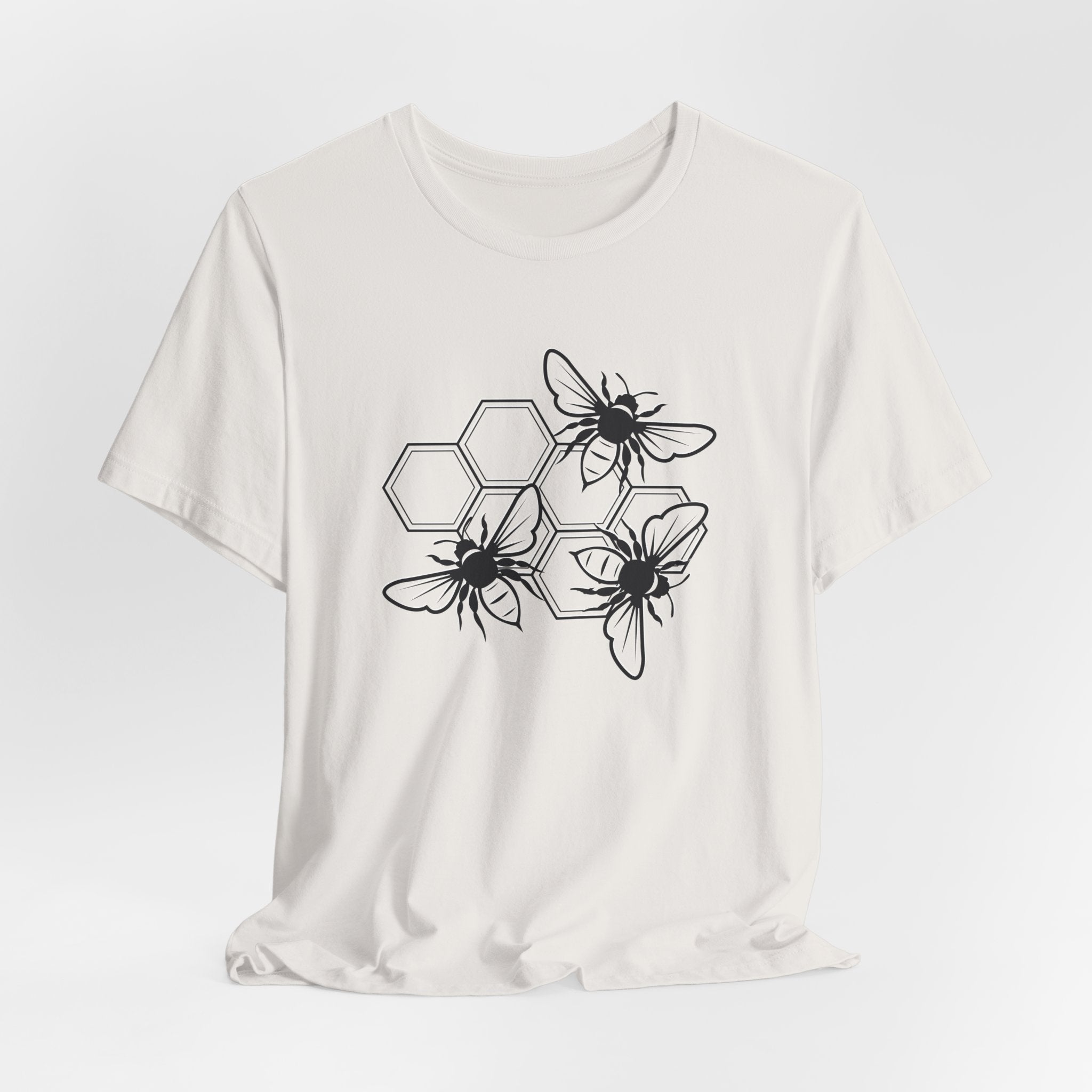 White t-shirt with black bee and hexagon pattern on a white background