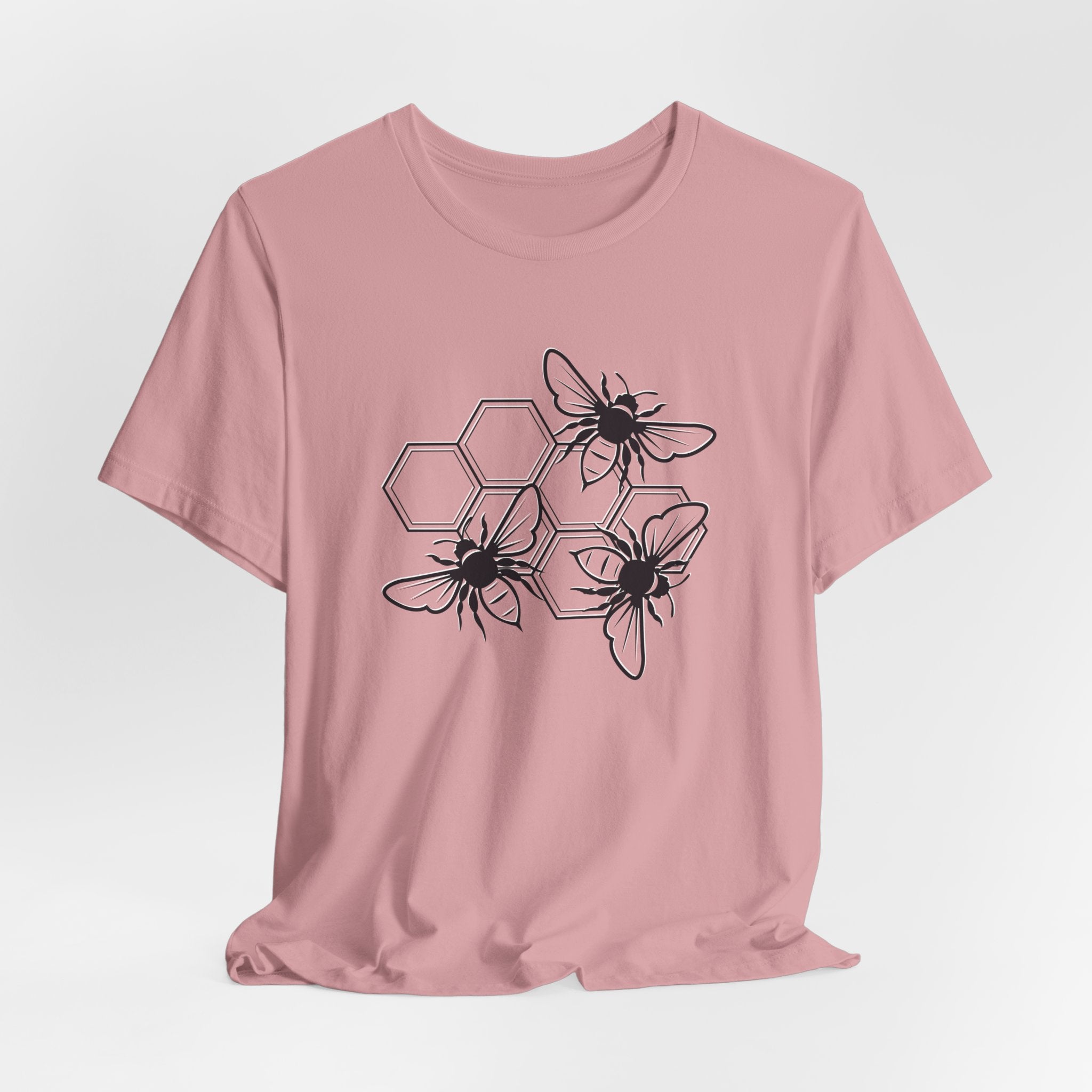 Pink t-shirt with black bee and honeycomb design on a light gray background