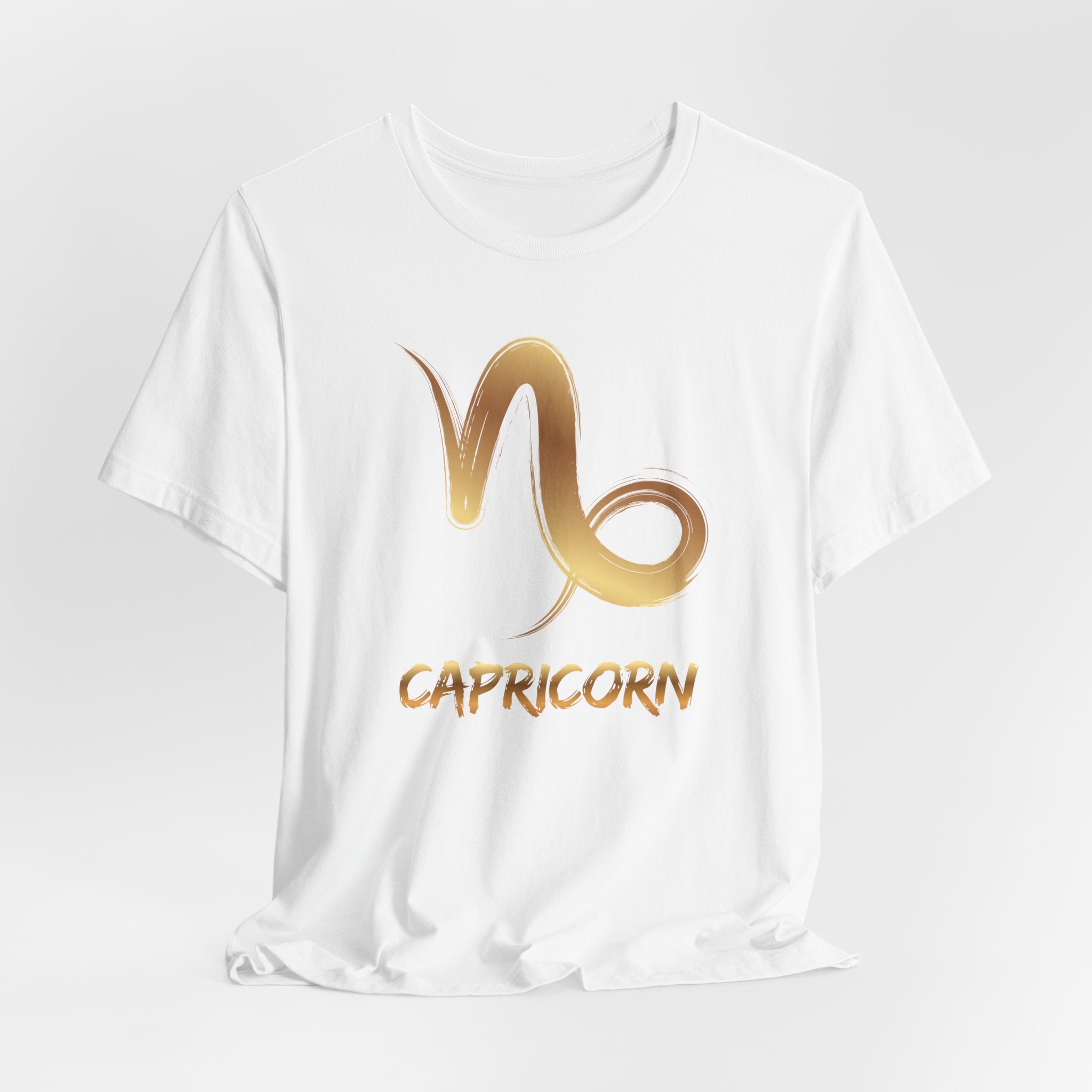 White t-shirt with gold Capricorn zodiac symbol on a white background