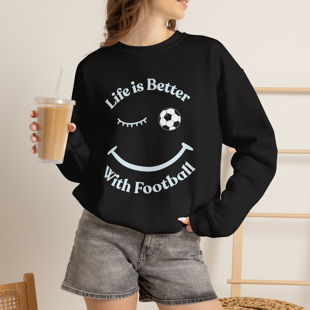 Person wearing a black sweatshirt with 'Life is Better With Football' text and smiley face design on a white background