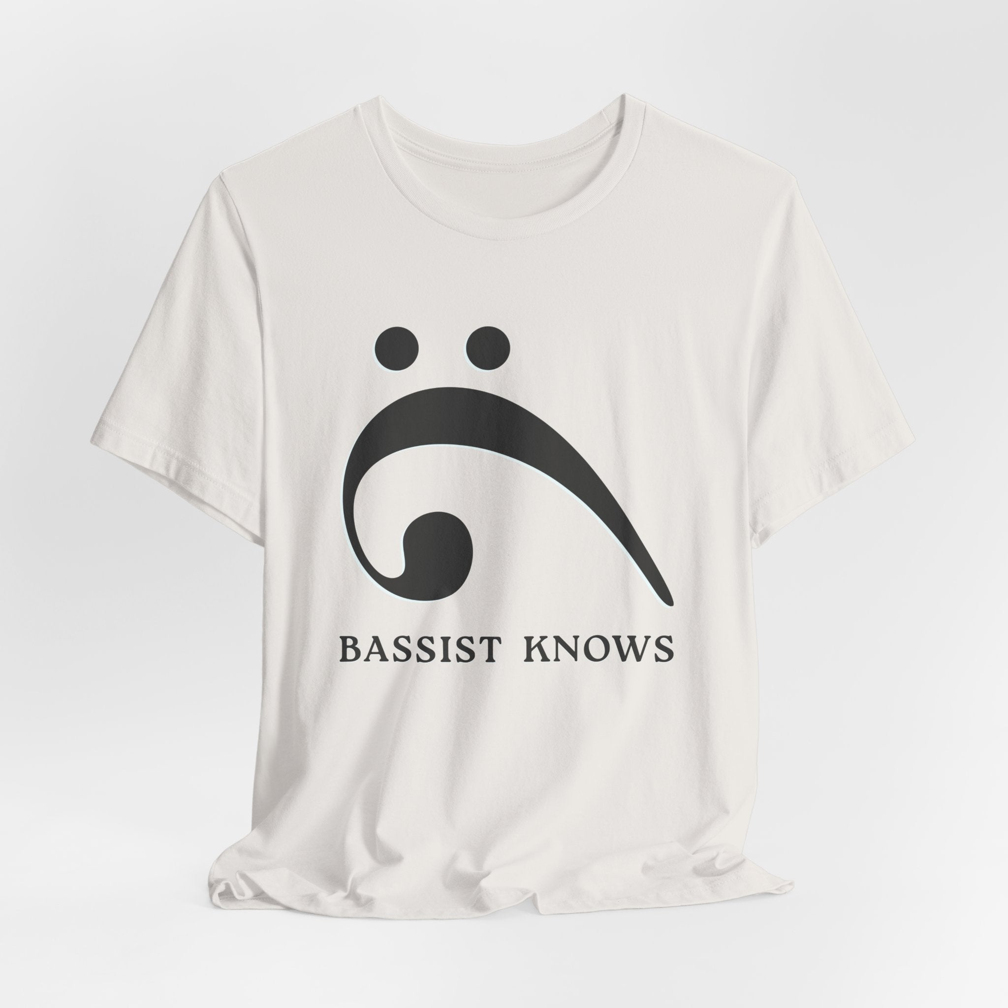 White t-shirt with black bass clef and 'Bassist Knows' text on a light gray background
