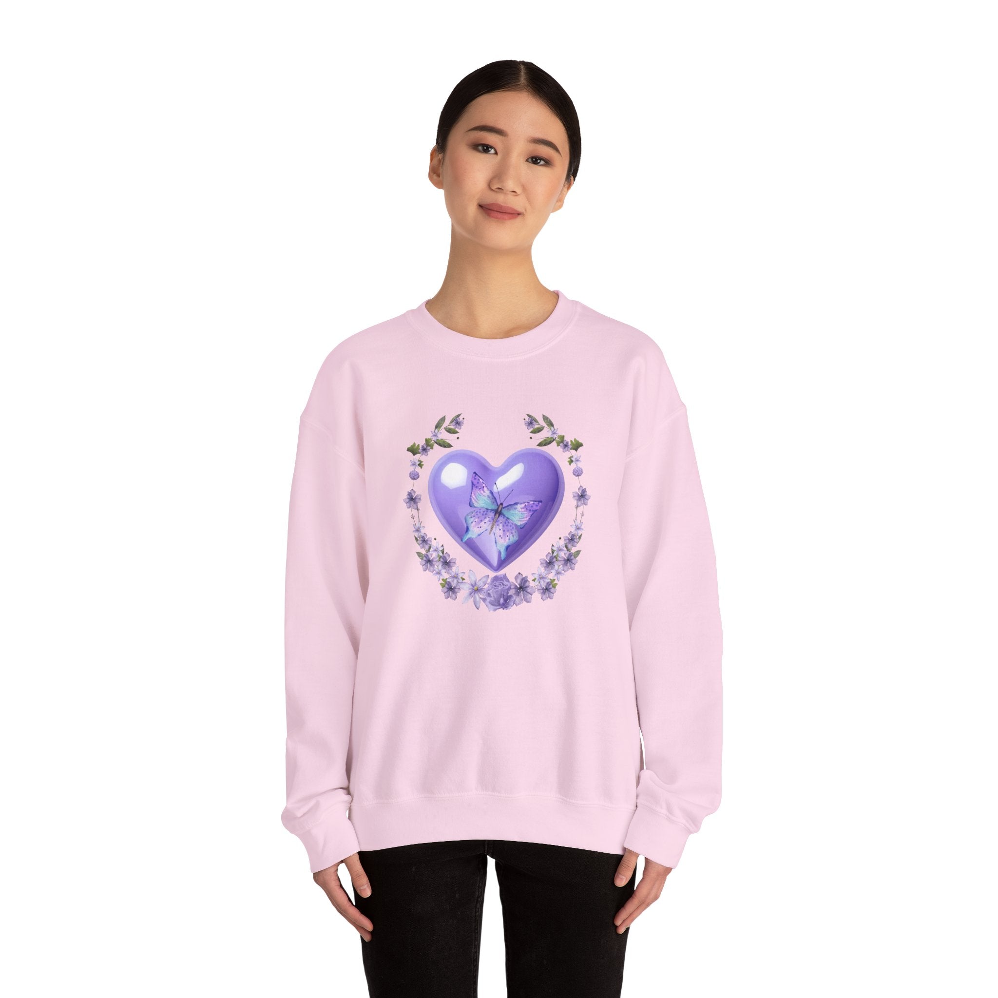 Person wearing a pink sweatshirt with a heart design on a white background
