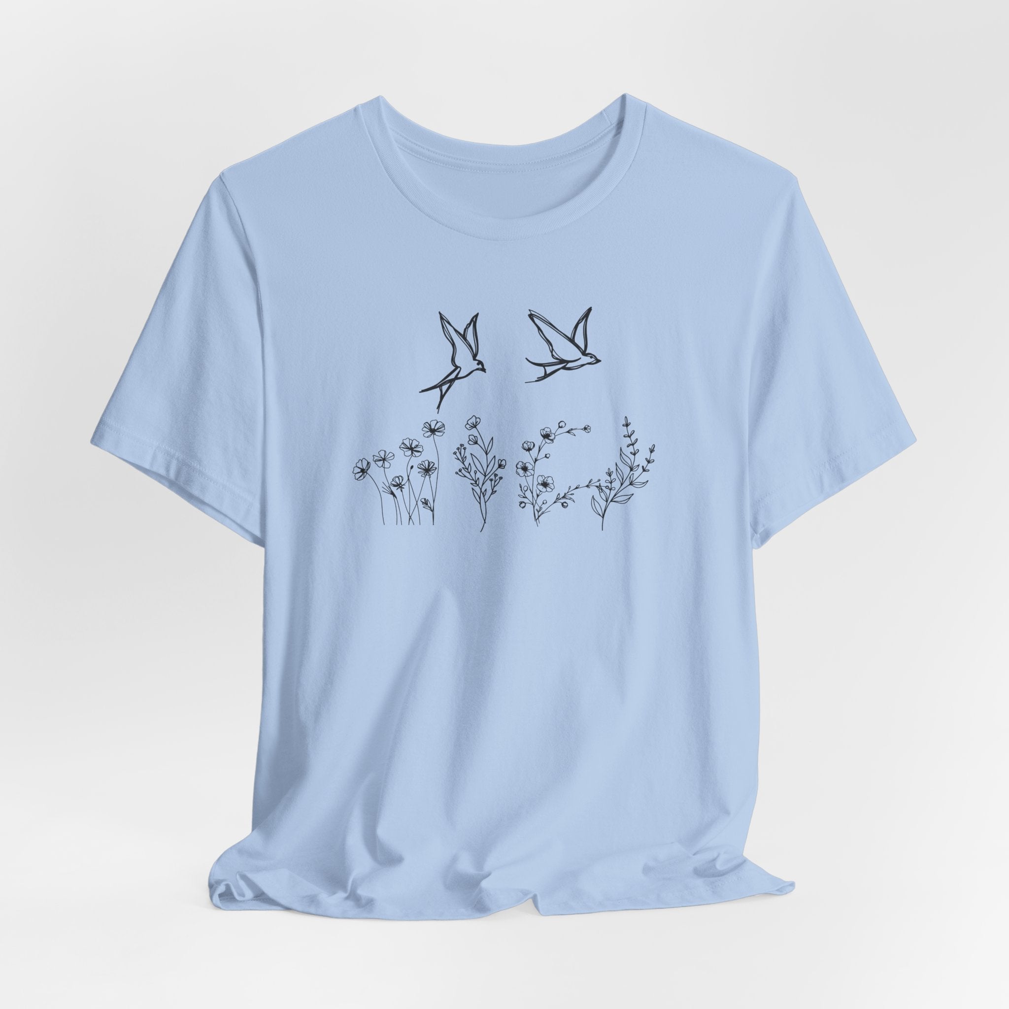 Light blue t-shirt with black bird and flower design on a light gray background
