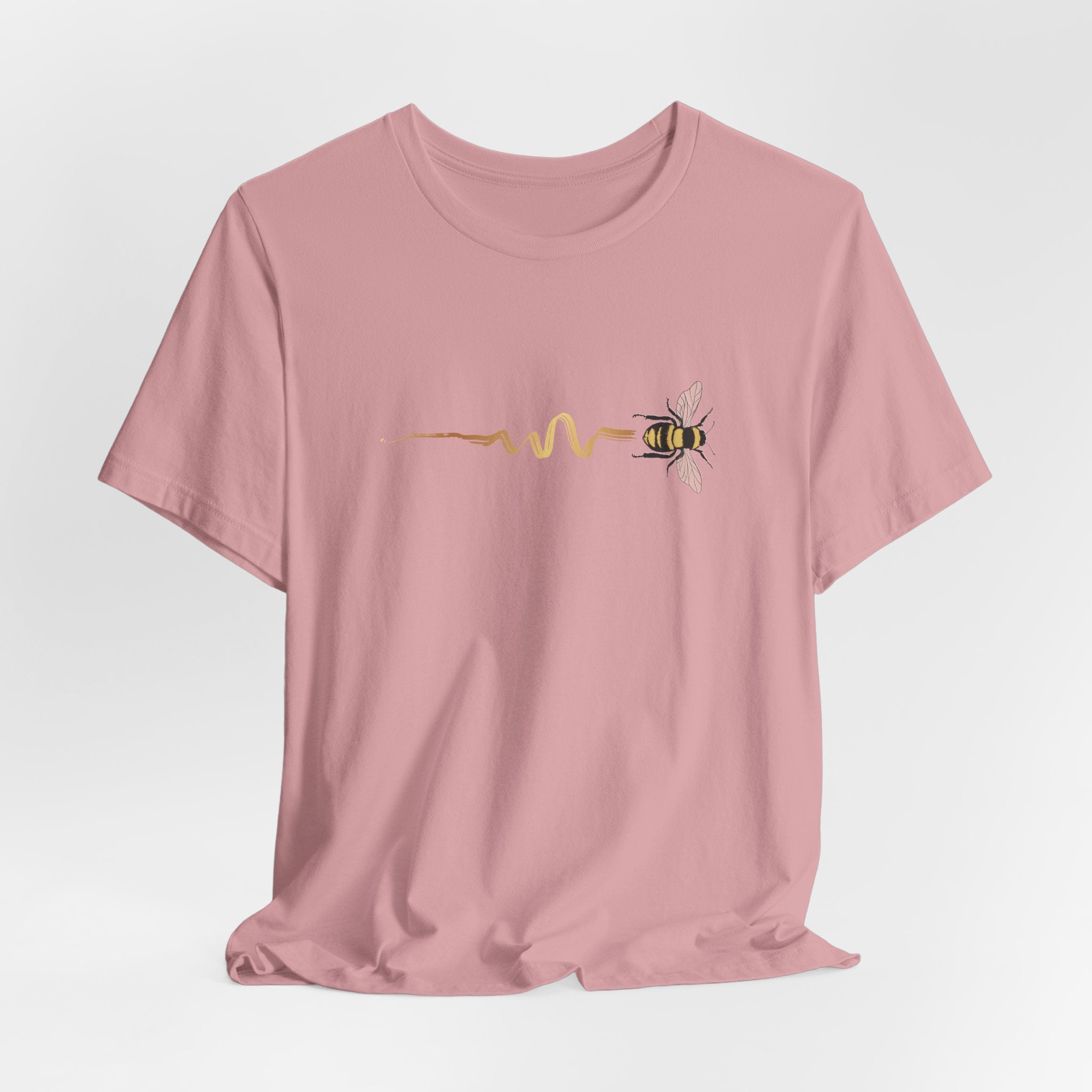 Pink t-shirt with a bee design on a light gray background